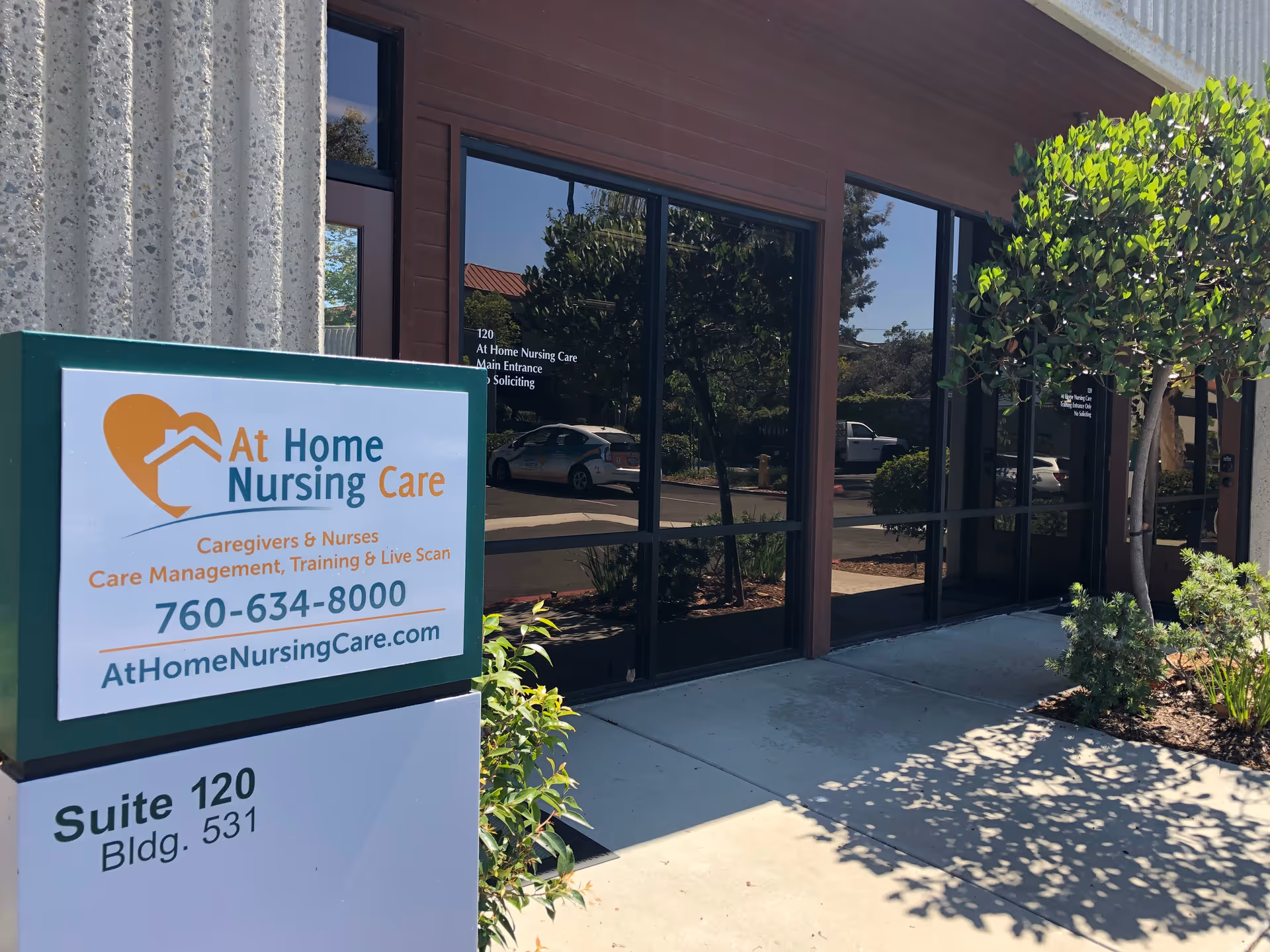 Exterior view of the facility entrance with a large sign for At Home Nursing Care.