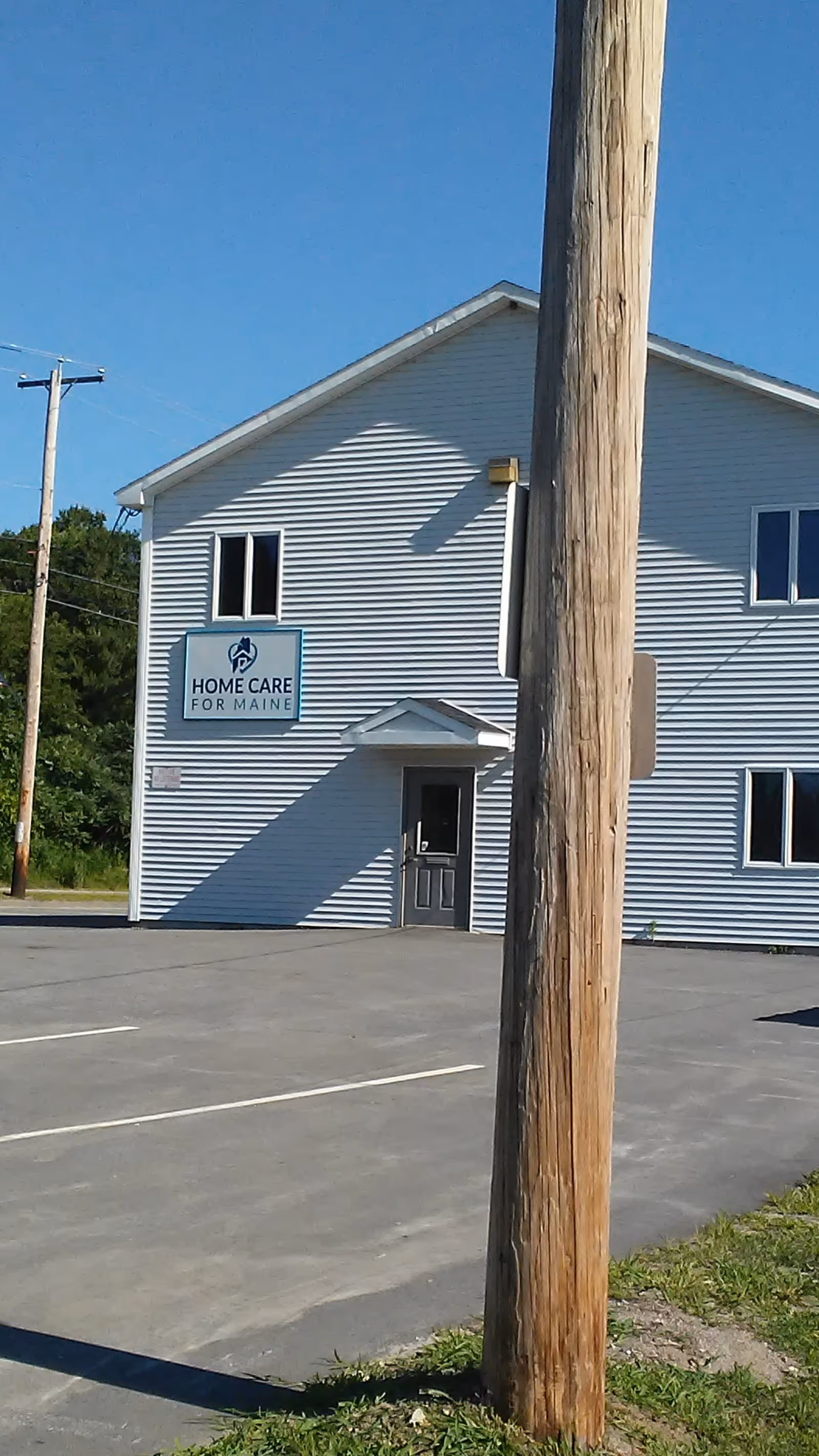 Exterior view of a Home Care for Maine facility with a sign and a parking lot.
