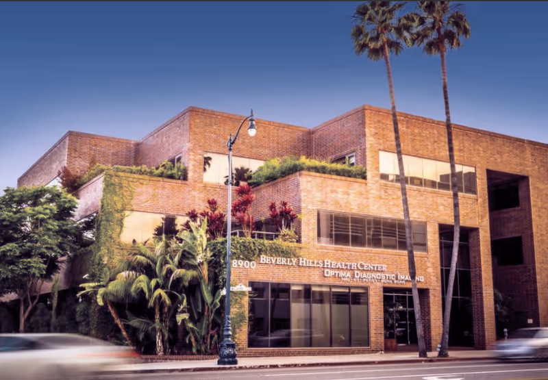 Exterior view of Beverly Hills Health Center, brick building with glass storefront and palm trees.