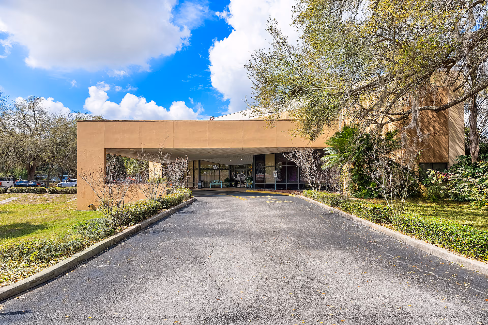 Auburndale Oaks Healthcare Center exterior with curved entrance and landscaping.