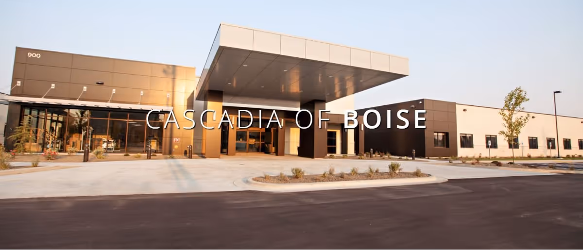 Exterior front view of a modern senior living facility building with a covered entrance and large windows, labeled Cascadia of Boise.