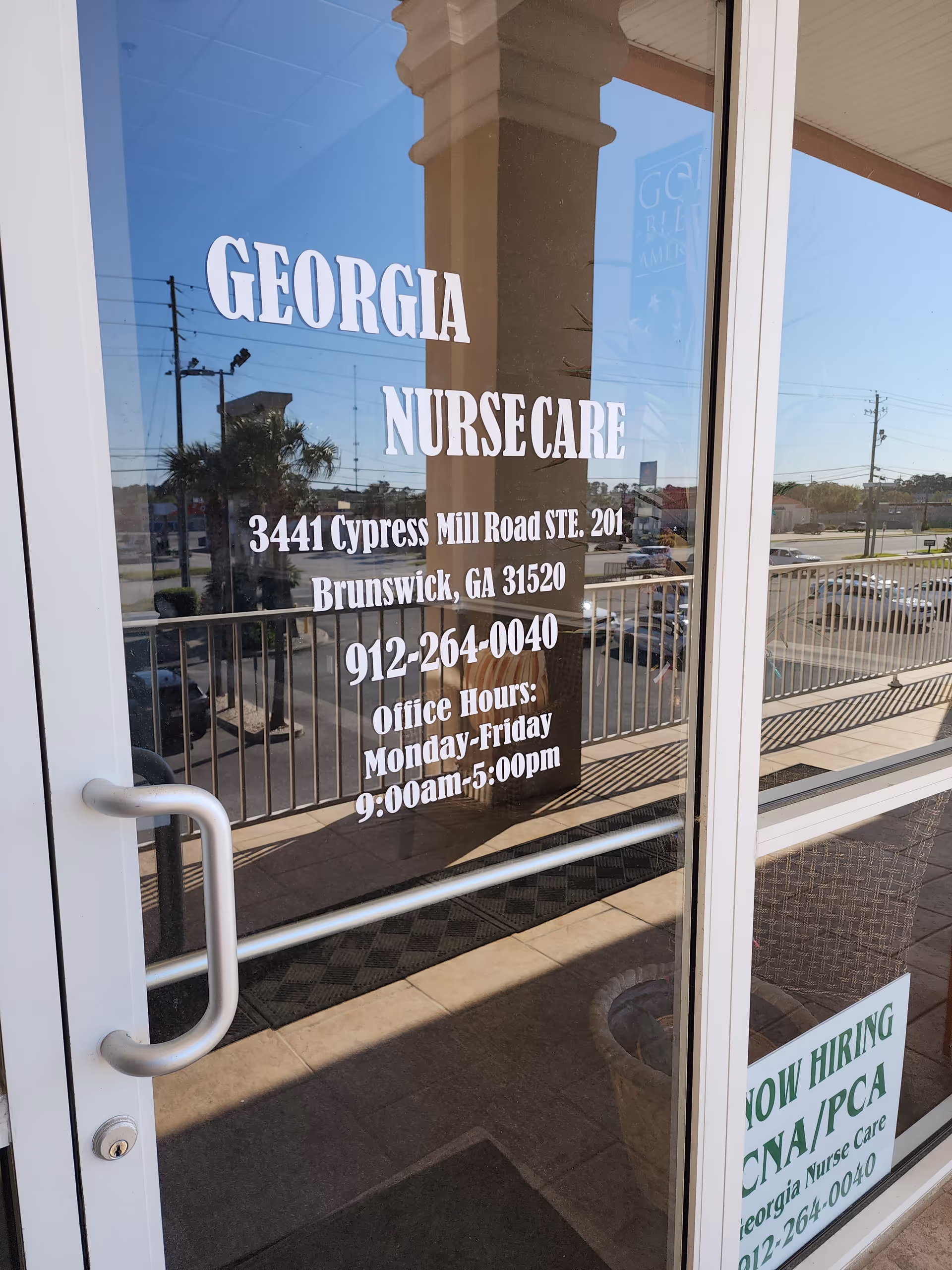 Glass storefront door showing Georgia NurseCare with address and hours.