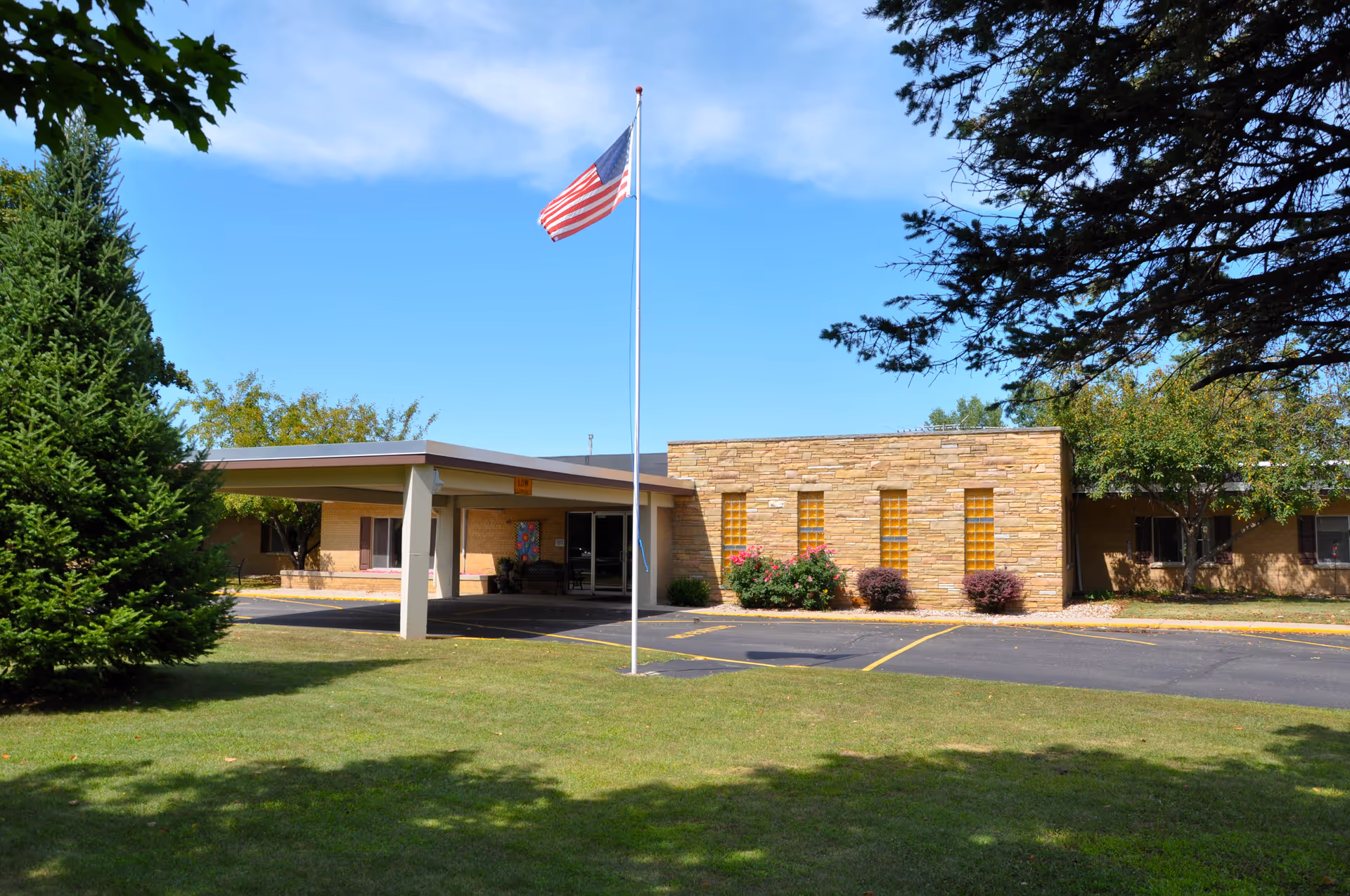 Front view of Greentree Health and Rehab Center with flagpole and entrance canopy.