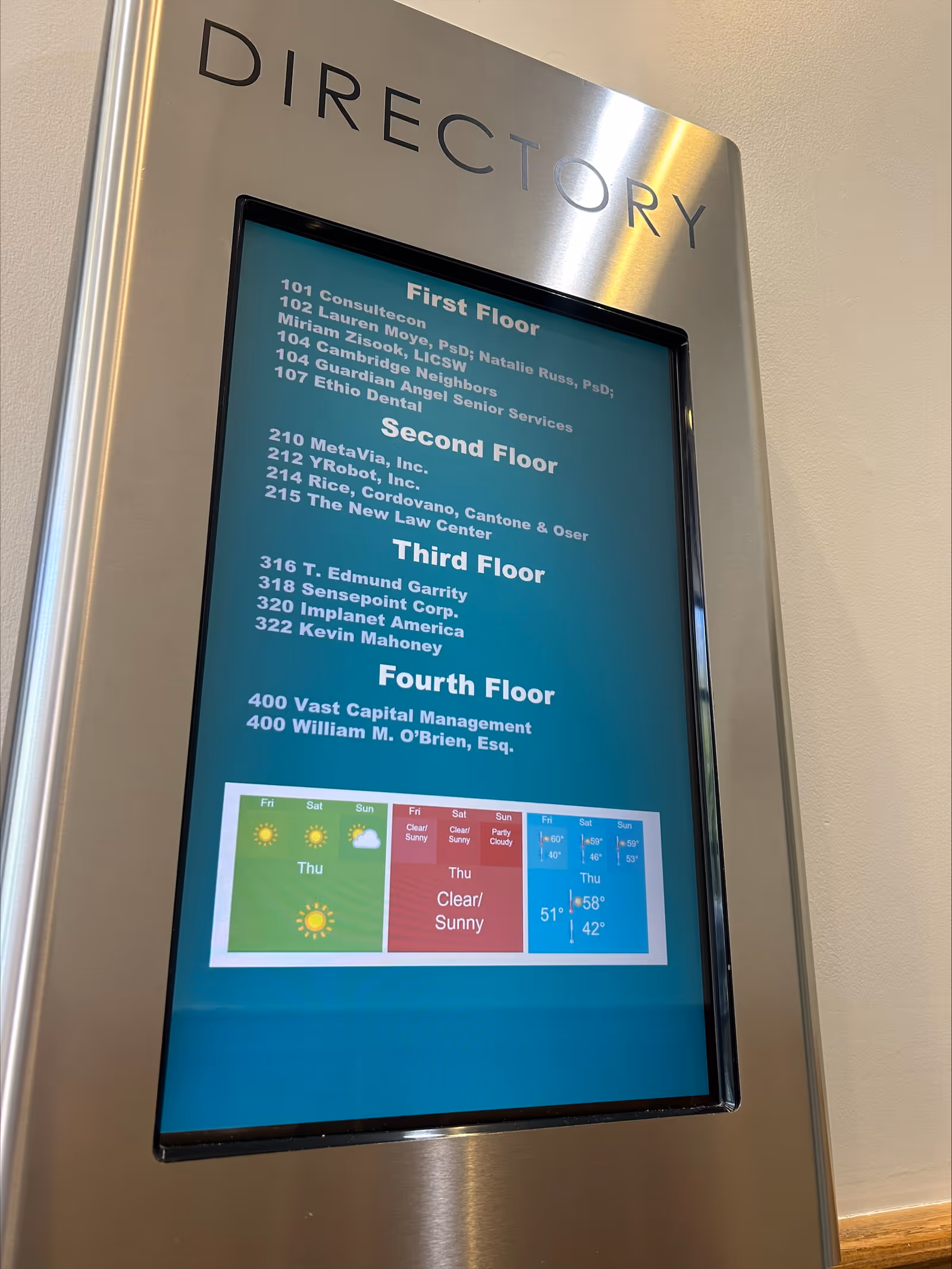 A stainless steel directory panel listing floors and tenants inside a senior living lobby.