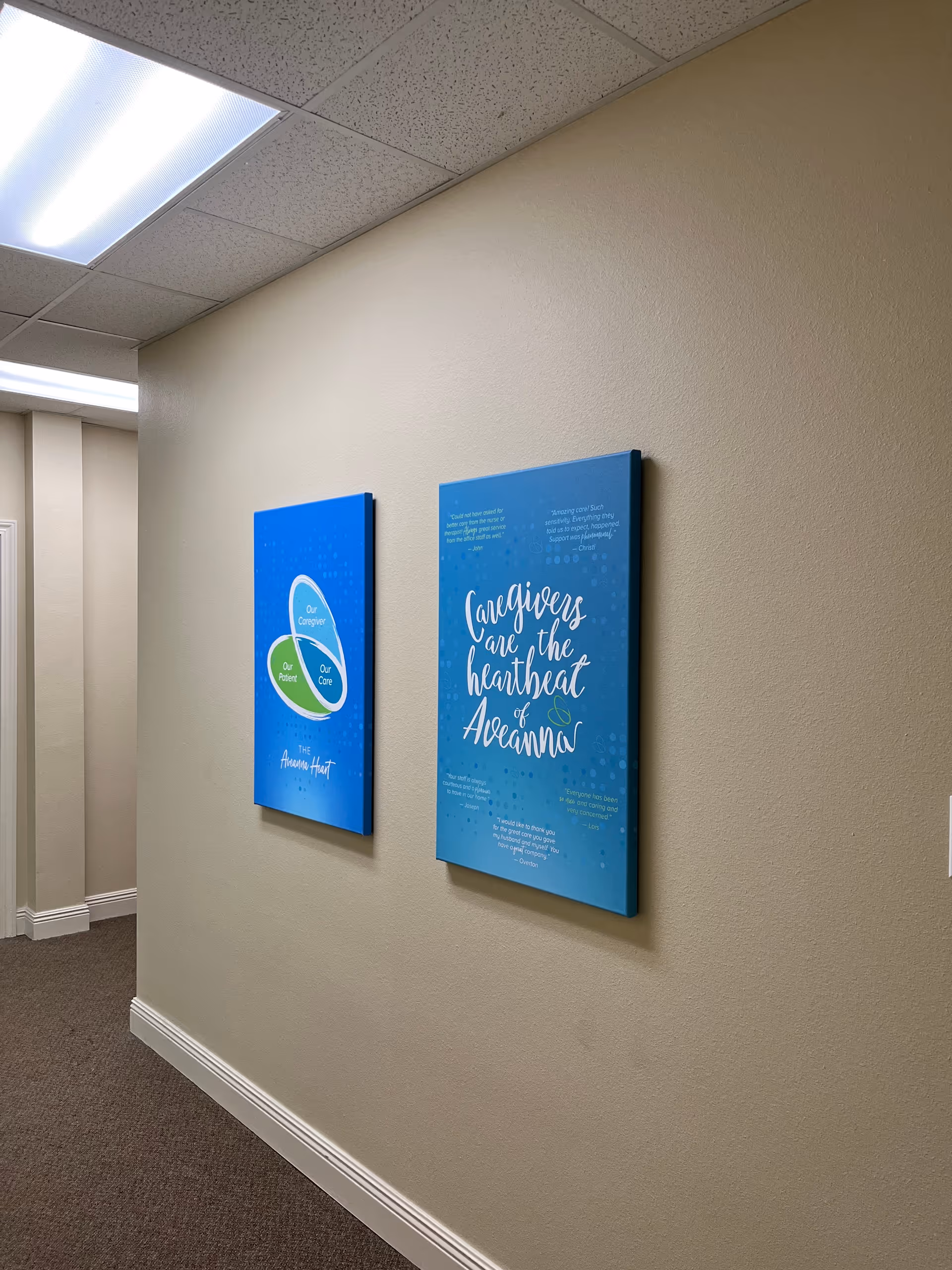 Interior hallway with beige walls and two blue framed posters.