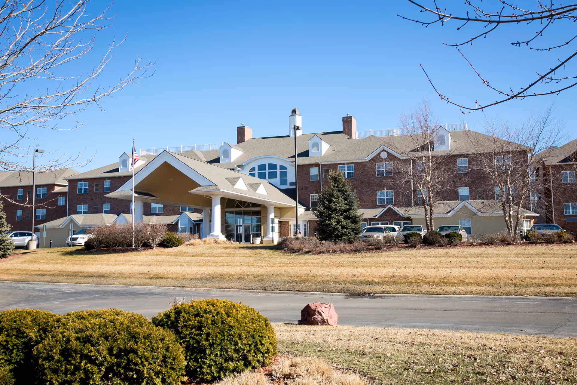 Exterior view of Walnut Grove Retirement Community with entrance canopy and landscaping.