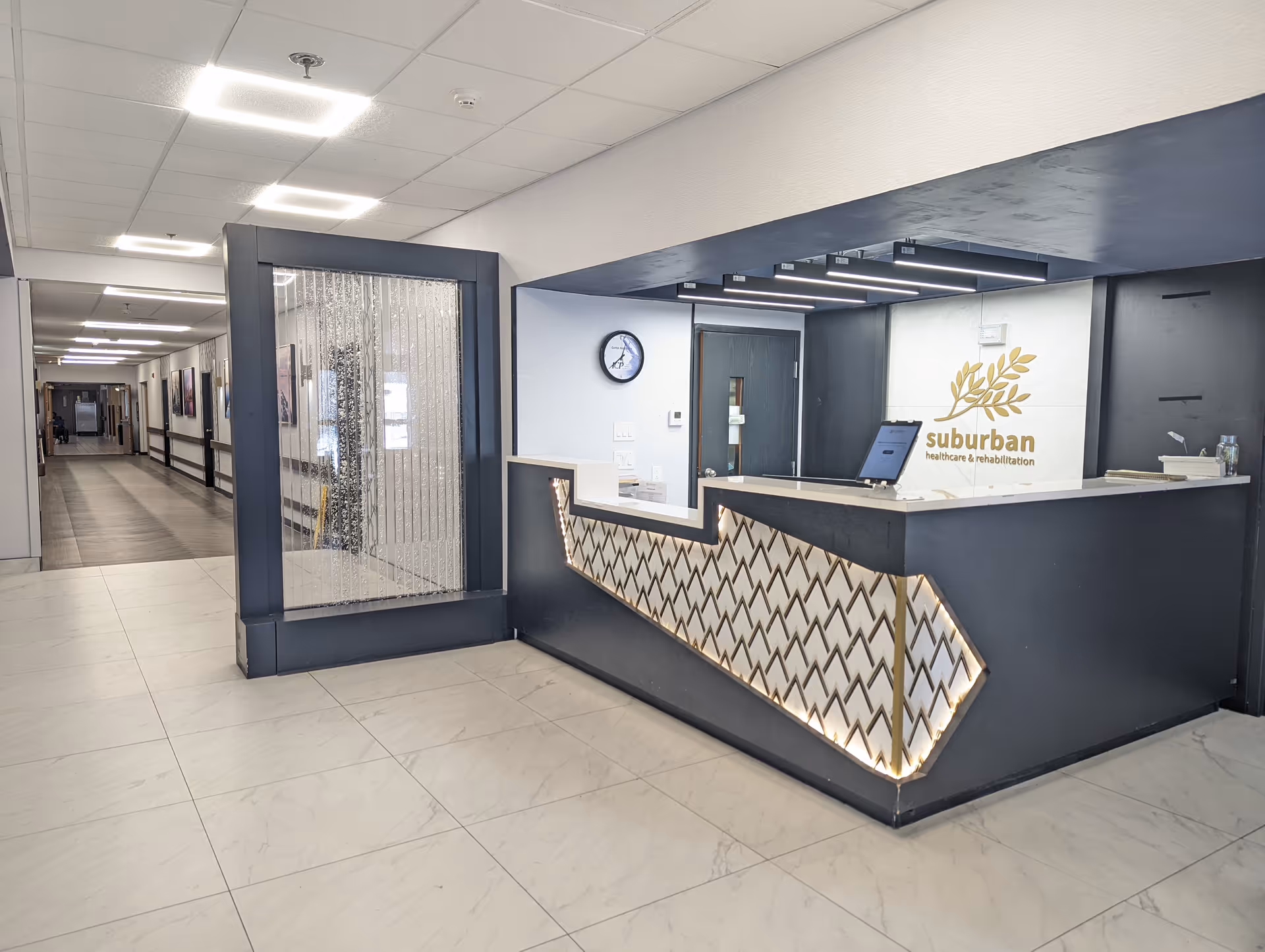 Reception lobby showing the Suburban Healthcare & Rehabilitation front desk, decorative counter, and adjacent hallway.