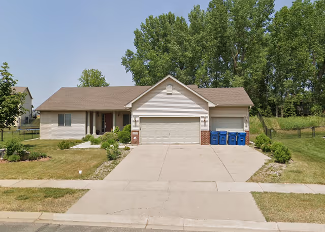 Front view of Gemini Manor building: a single-family home with a two-car garage and well-kept yard.