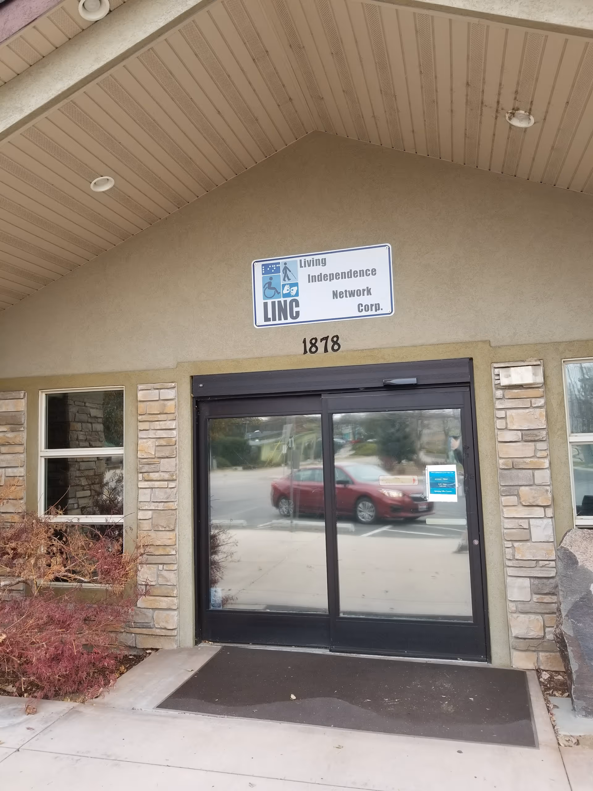 Exterior view of a building entrance with a sign reading Living Independence Network Corp.