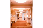 Long indoor corridor in a retirement community with warm lighting and arches.