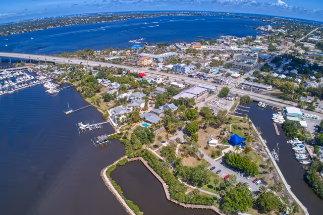 Aerial view of a coastal town with waterways, docks, and boats.