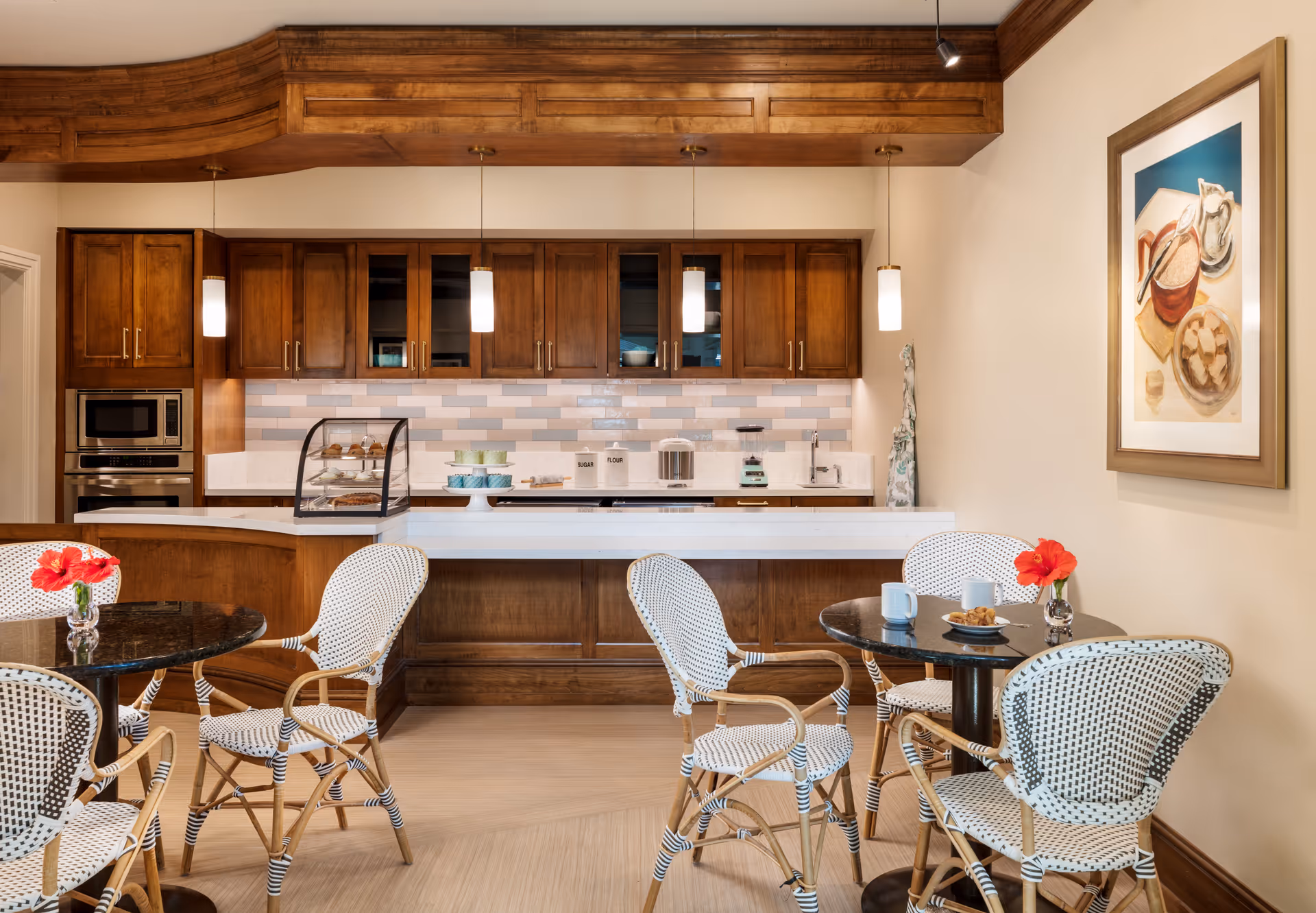 Open kitchen with wooden cabinets, backsplash, and small dining tables with woven chairs.