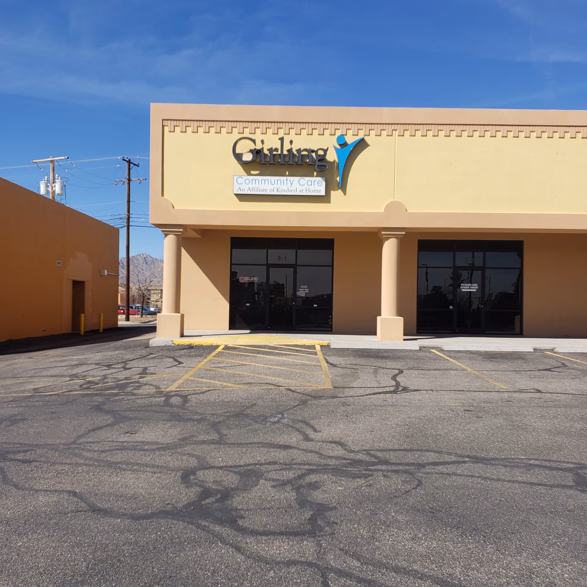 Exterior view of Girling Personal Care facility with entrance doors and parking lot.