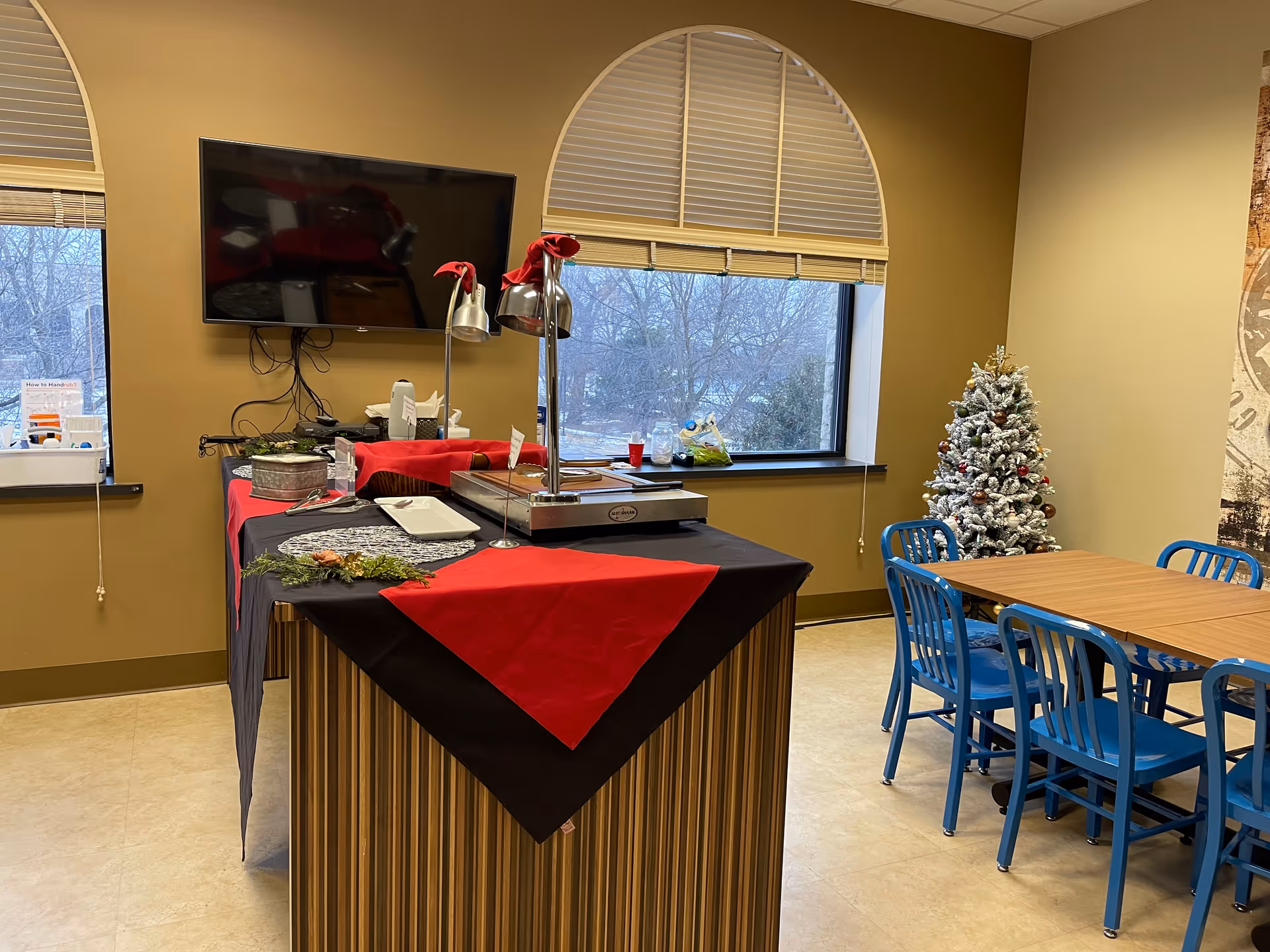 Senior living dining room with buffet station, blue chairs, and a Christmas tree.
