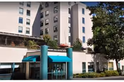 Exterior of Workmens Circle Multicare Center with glass doors and teal entrance columns.