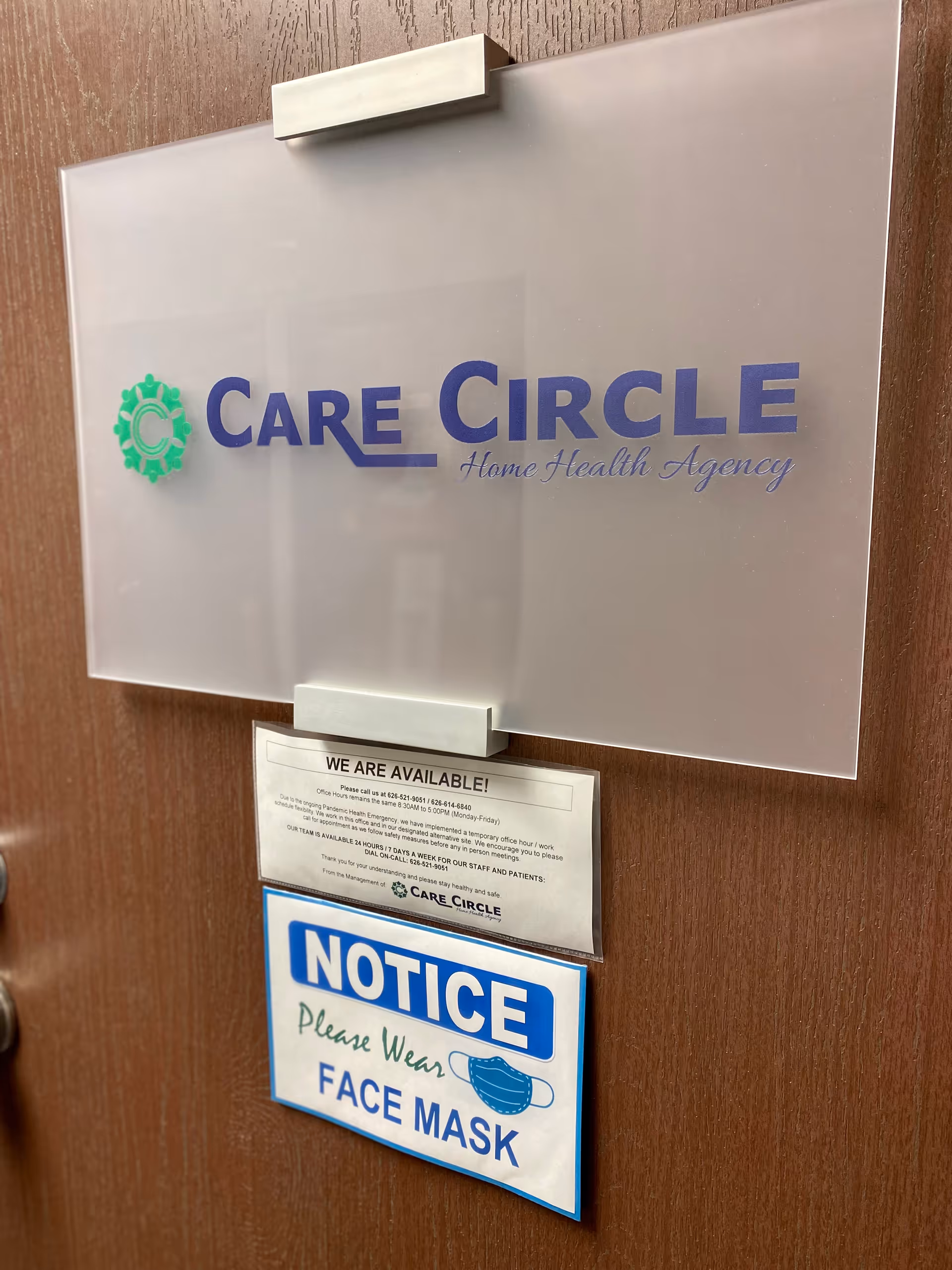 Wooden door with Care Circle Home Health Agency sign and posted notices