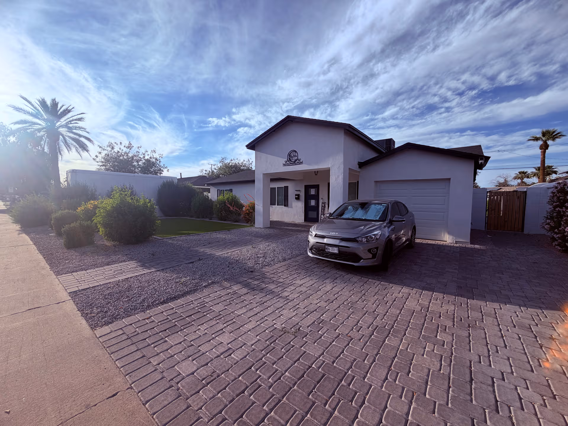 Front view of Colter Luxury Assited Living facility with a parked car and palm trees
