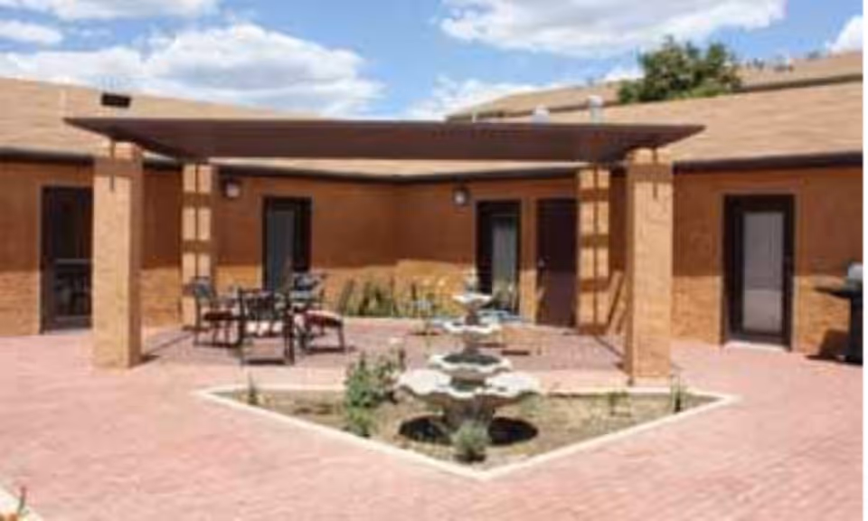 Outdoor courtyard with a central fountain, patio seating, and a shaded area.