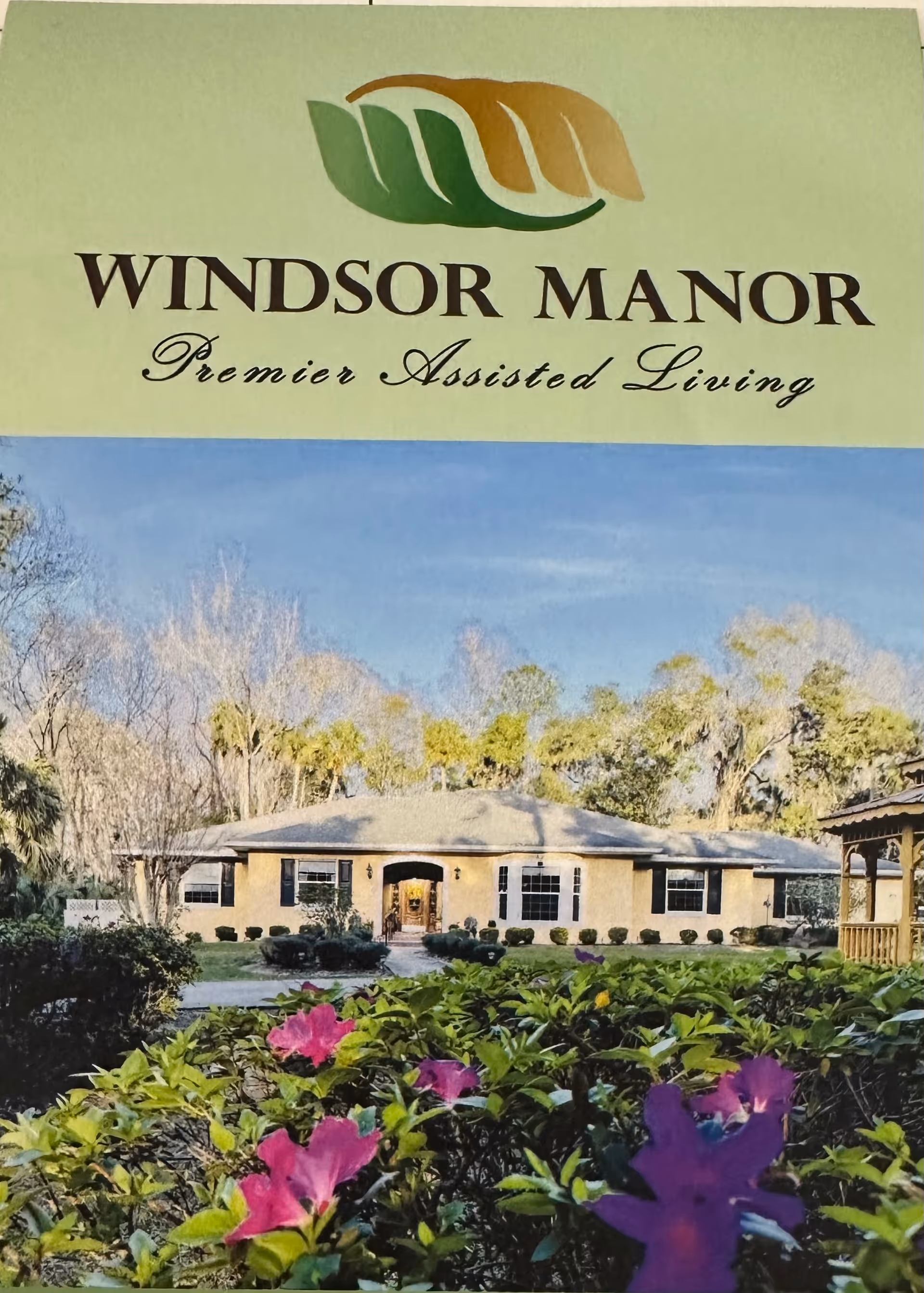 Sign reads Windsor Manor Premier Assisted Living with a single-story building and landscaped front yard.