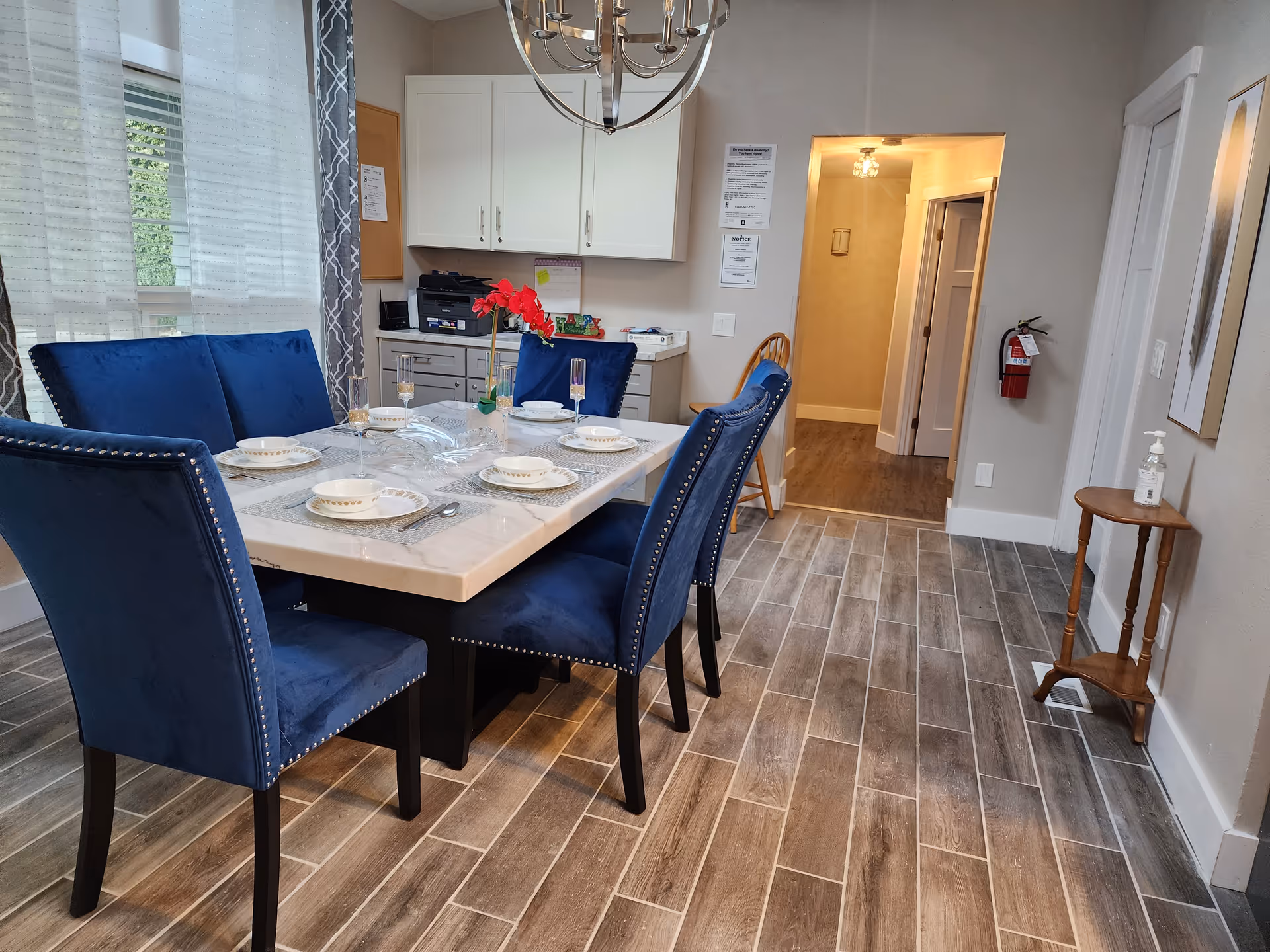 Blue upholstered chairs surround a glass-topped dining table in a modern dining room.