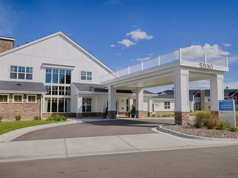 The front exterior and covered porte-cochère entrance of a senior living building displaying the number 5530.