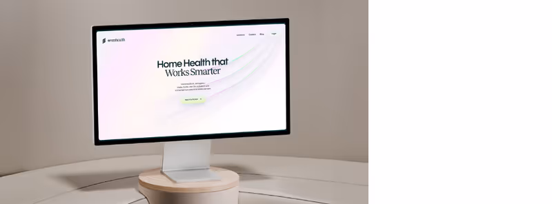 A computer monitor on a curved white desk in a clean, neutral interior.