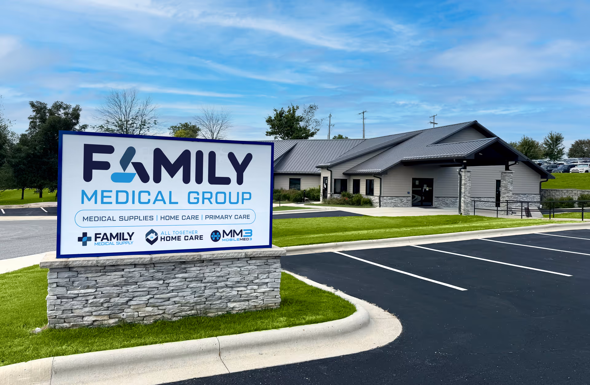 Exterior view of a modern facility with a Family Medical Group sign and All Together logo.