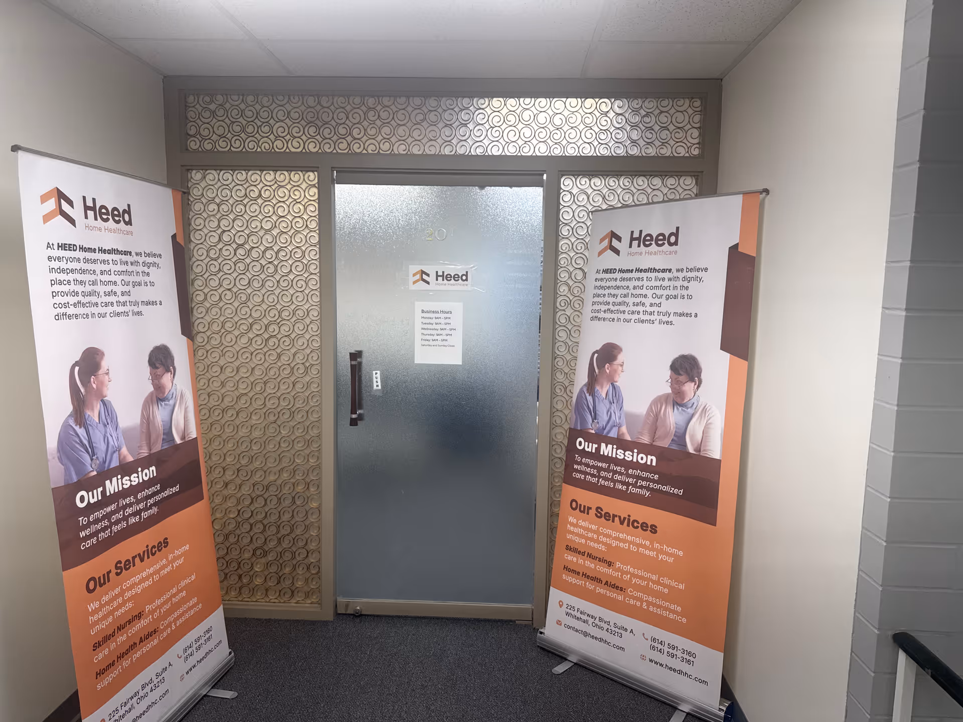 Narrow hallway with frosted glass door and two Heed Home Healthcare banners.