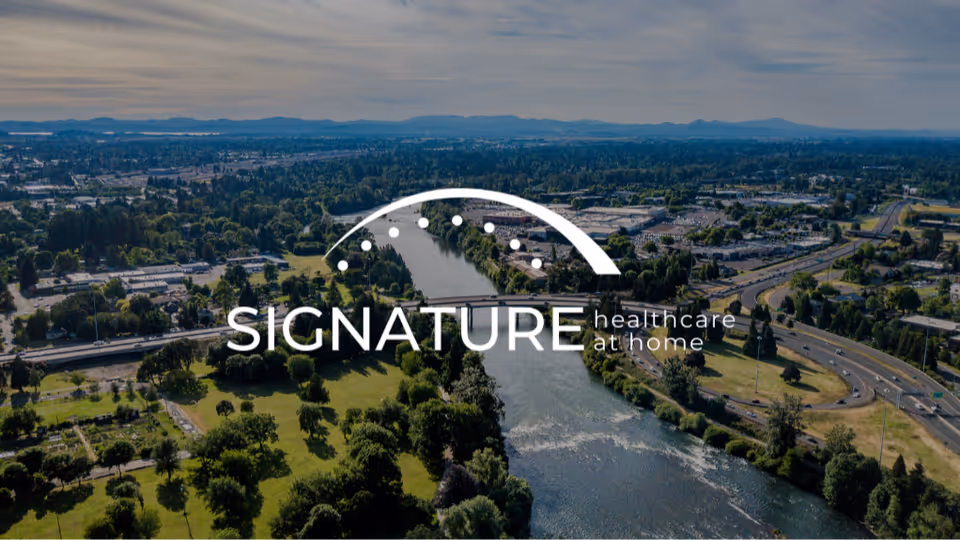 Aerial view of a river, roads, and green spaces with Signature Healthcare at Home logo.