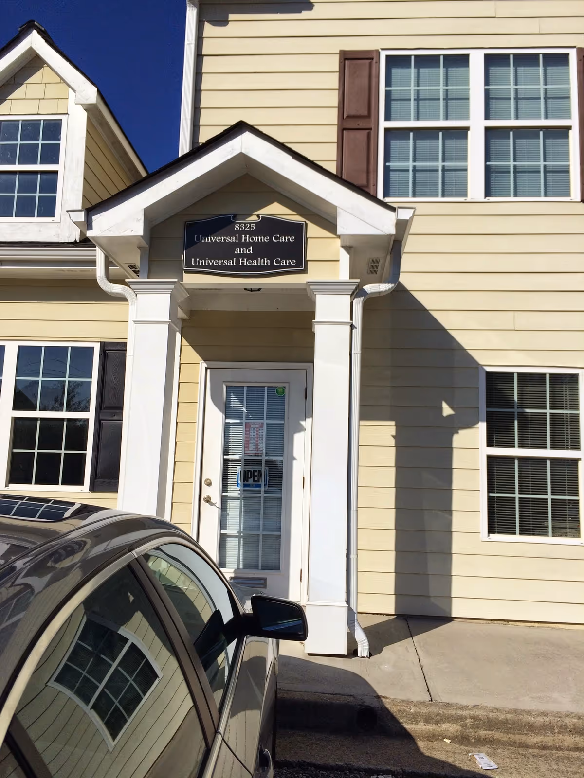 Front entrance of Universal Home Care/Complete Home Care facility with beige siding.