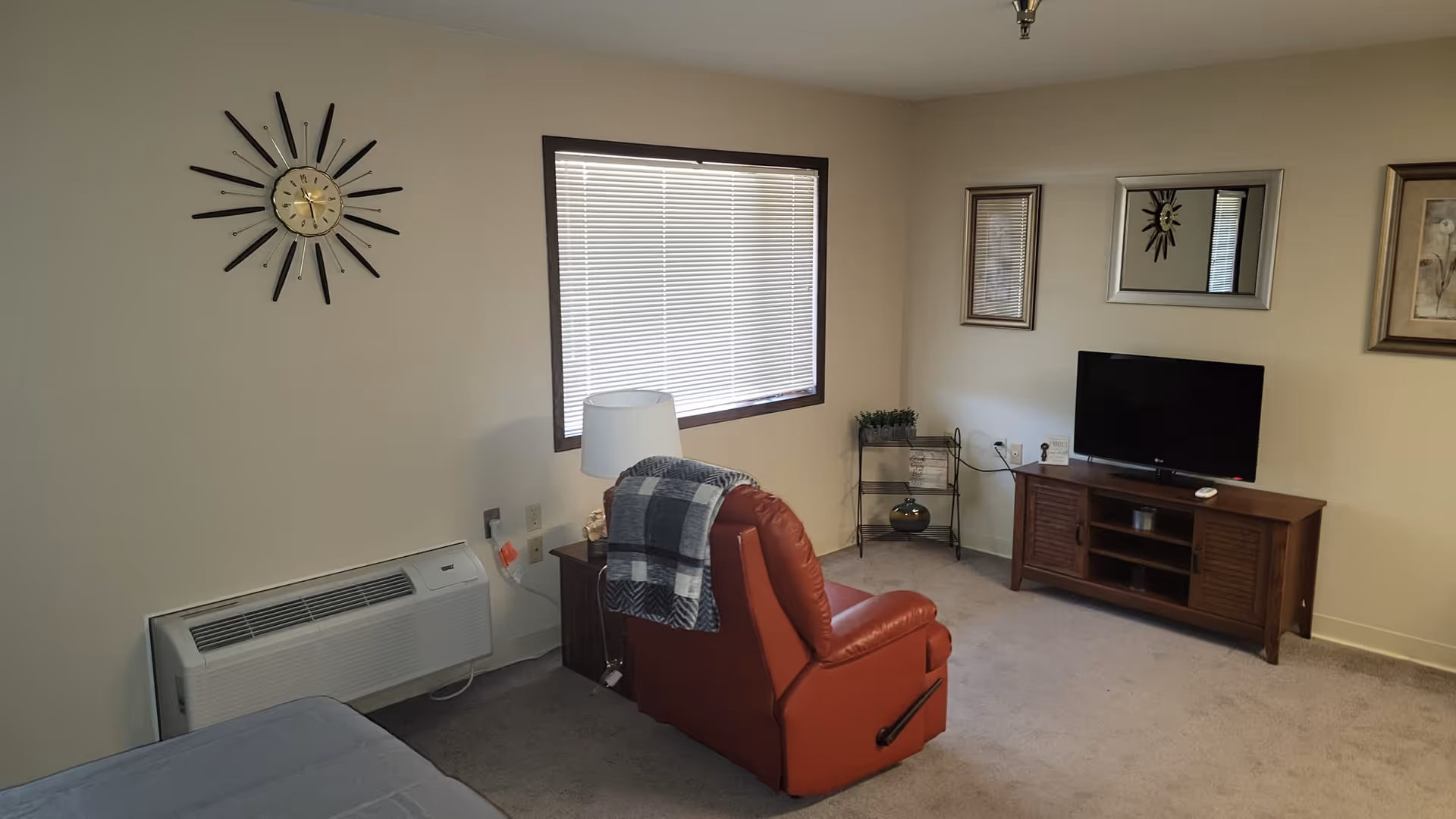 Red recliner and TV console in a cozy senior living room.