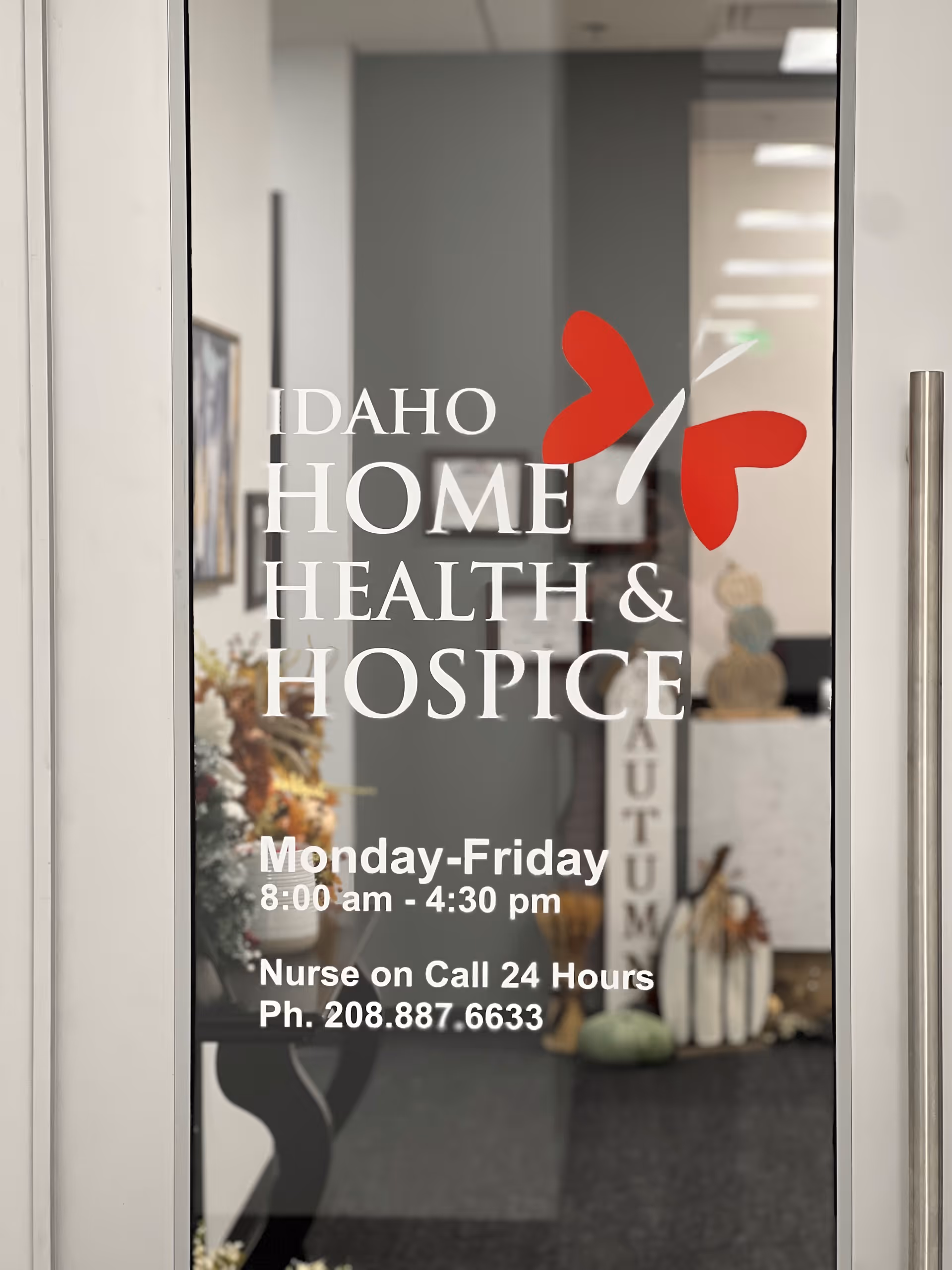 Glass door shows Idaho Home Health & Hospice sign and hours inside the facility.