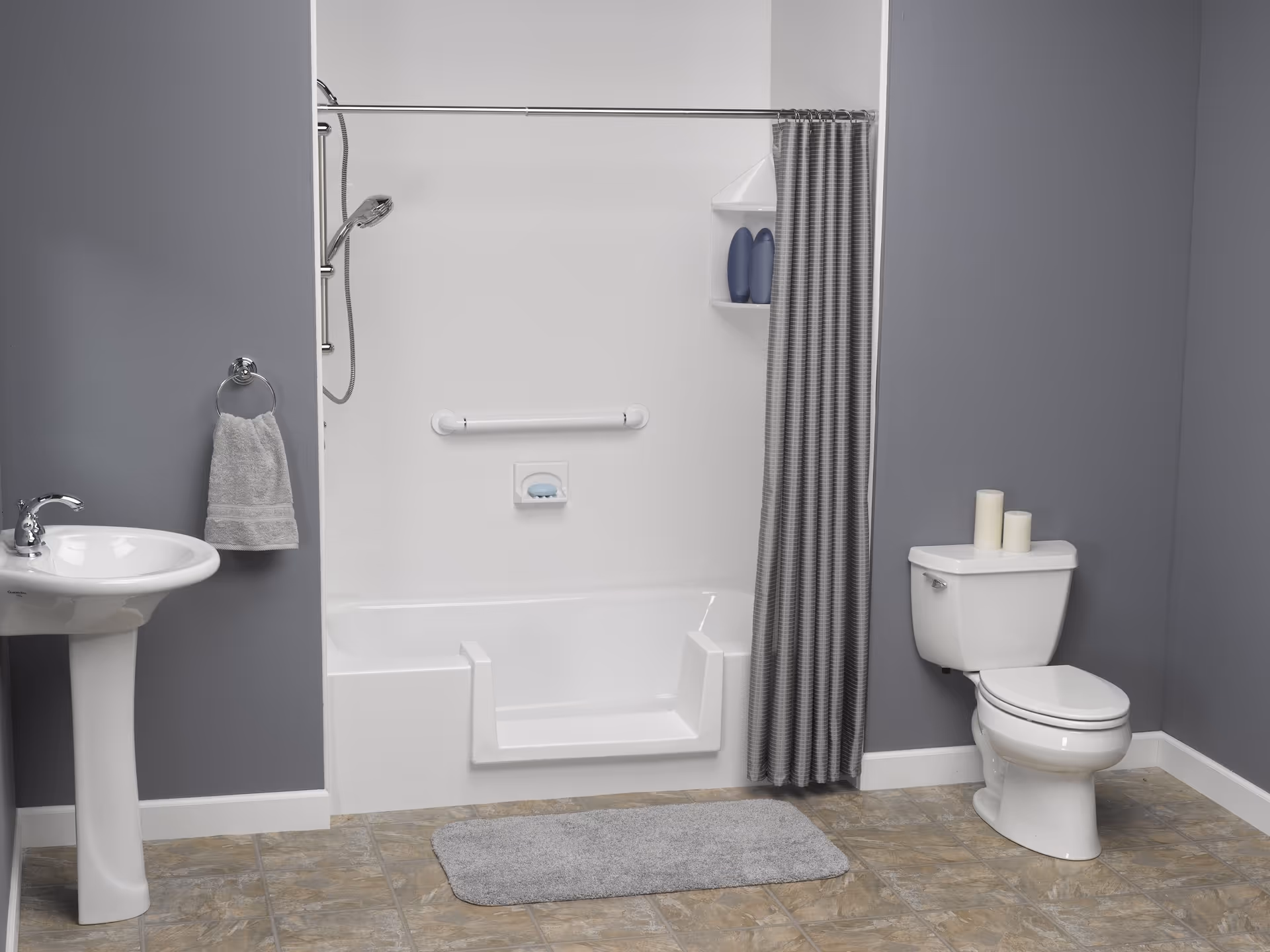 Accessible bathroom with walk-in tub, grab bar, shower curtain, sink, toilet, and gray walls.