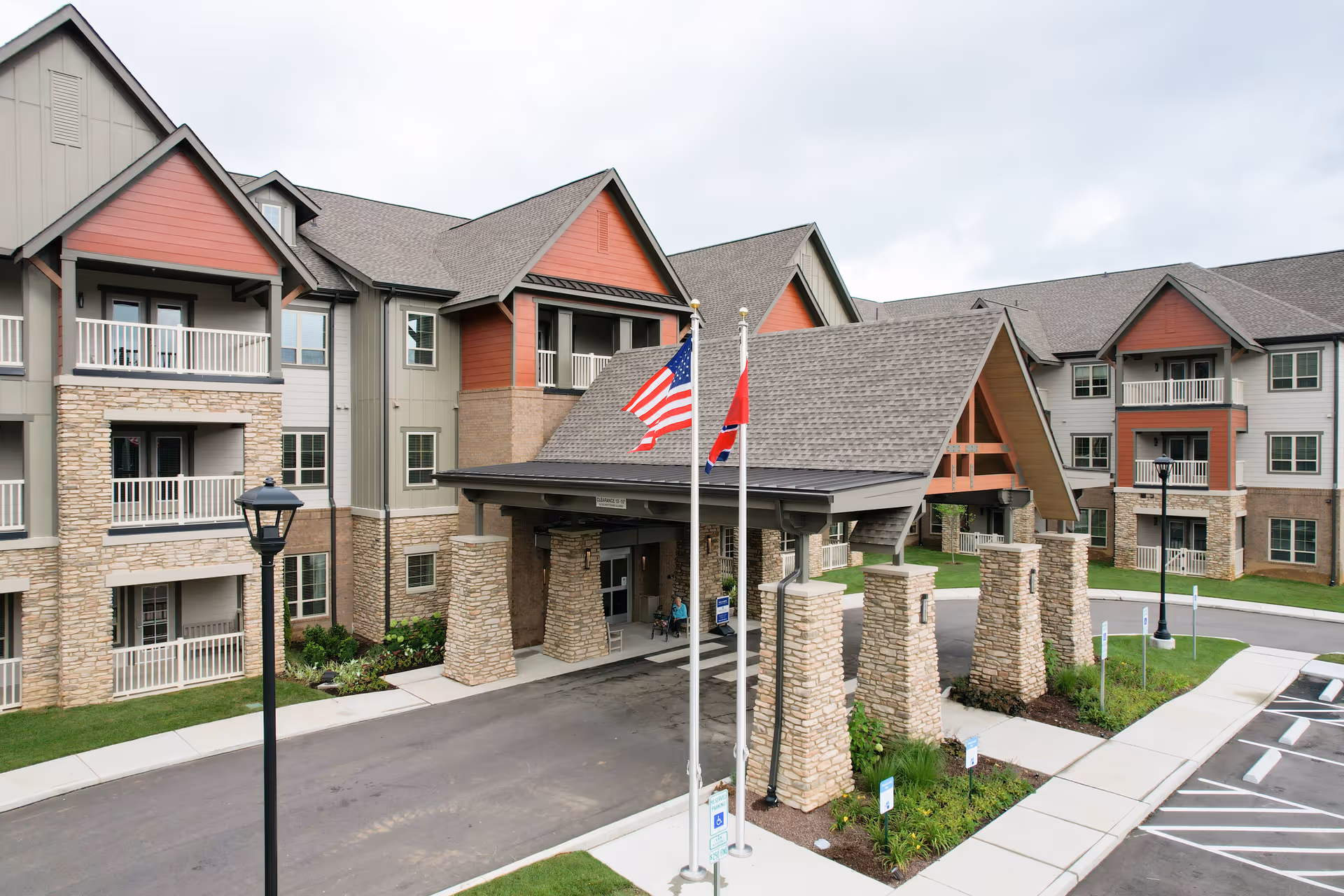 Exterior view of Harmony at Bellevue with stone pillars and a covered entrance.