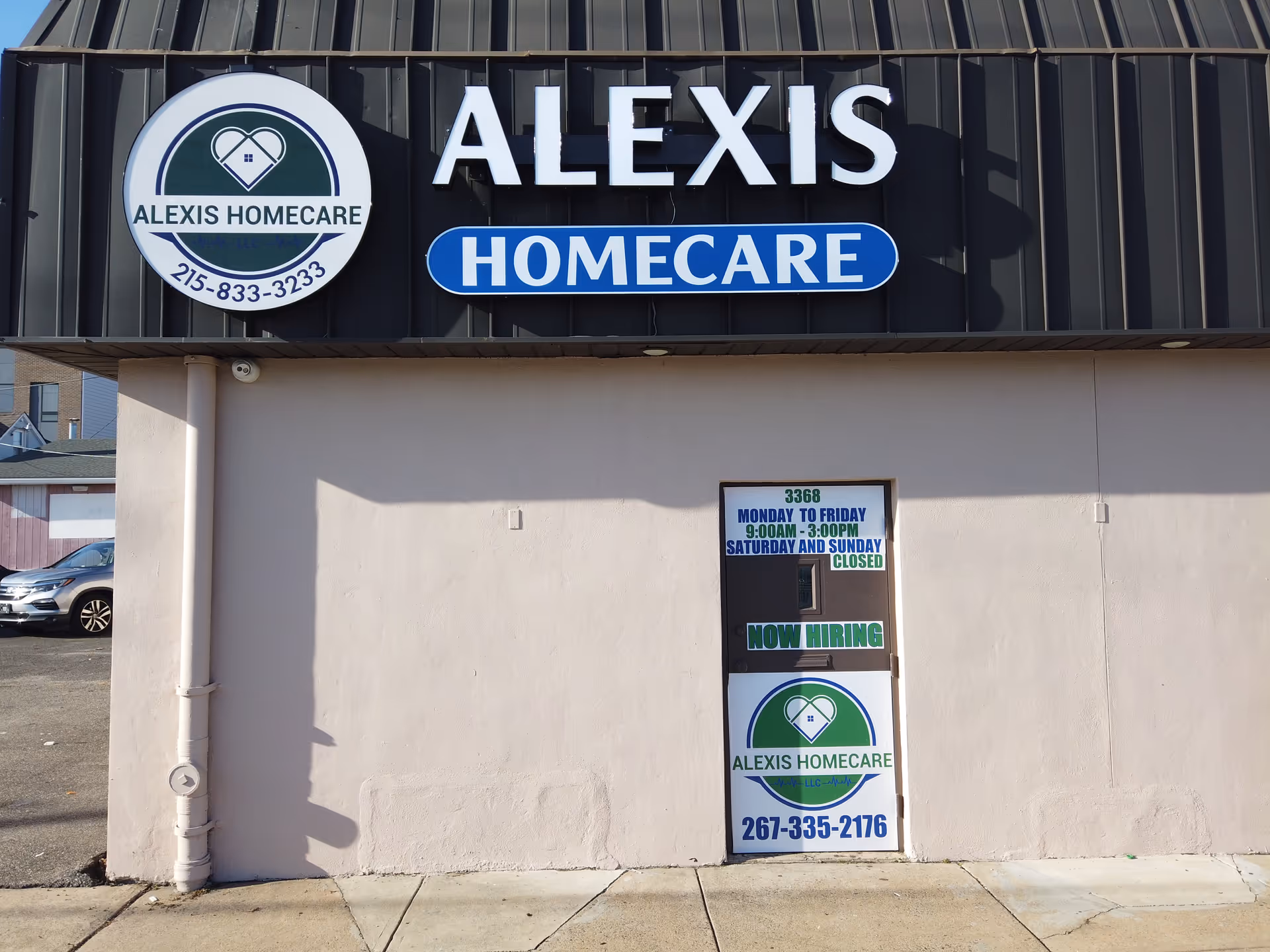 Exterior of Alexis Homecare storefront with large lettering, circular logo, and now hiring sign.