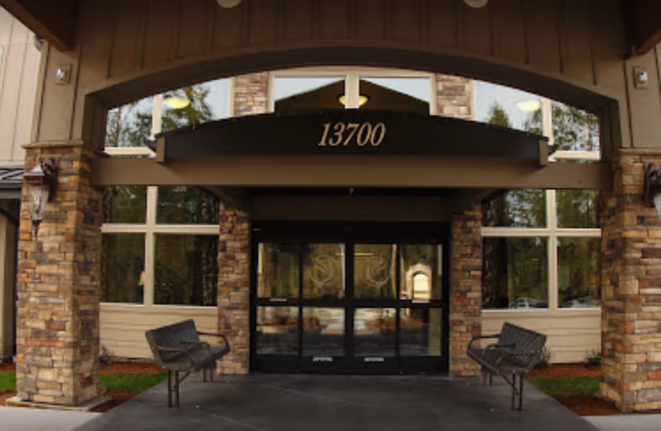 Entrance to Bonaventure of Salmon Creek, featuring stone pillars and glass doors.