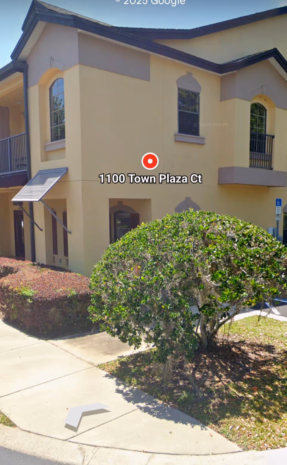 Exterior view of AHAA Moment Home Care building with beige walls and landscaping.