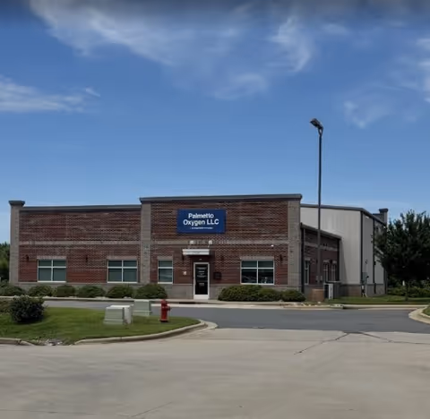 Exterior view of Palmetto Oxygen LLC building with brick facade and parking lot.