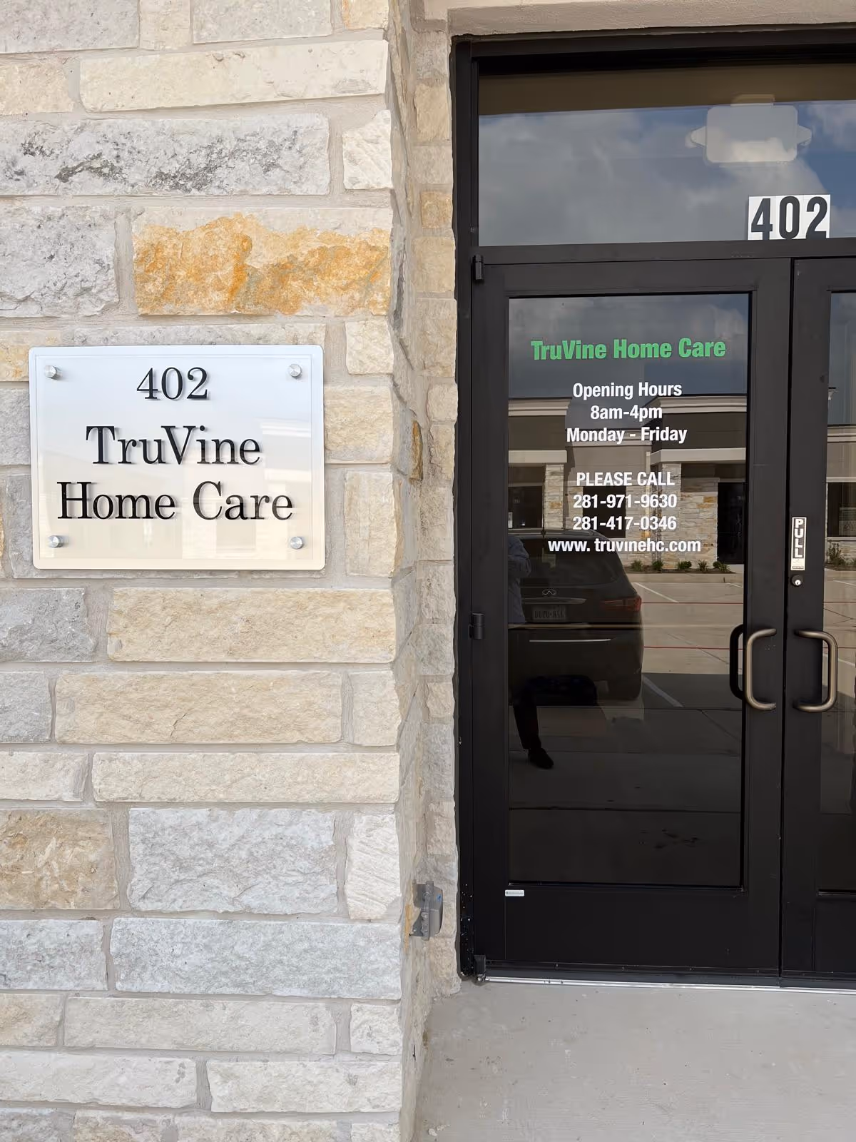 Stone exterior with a glass door entrance and TruVine Home Care signage.