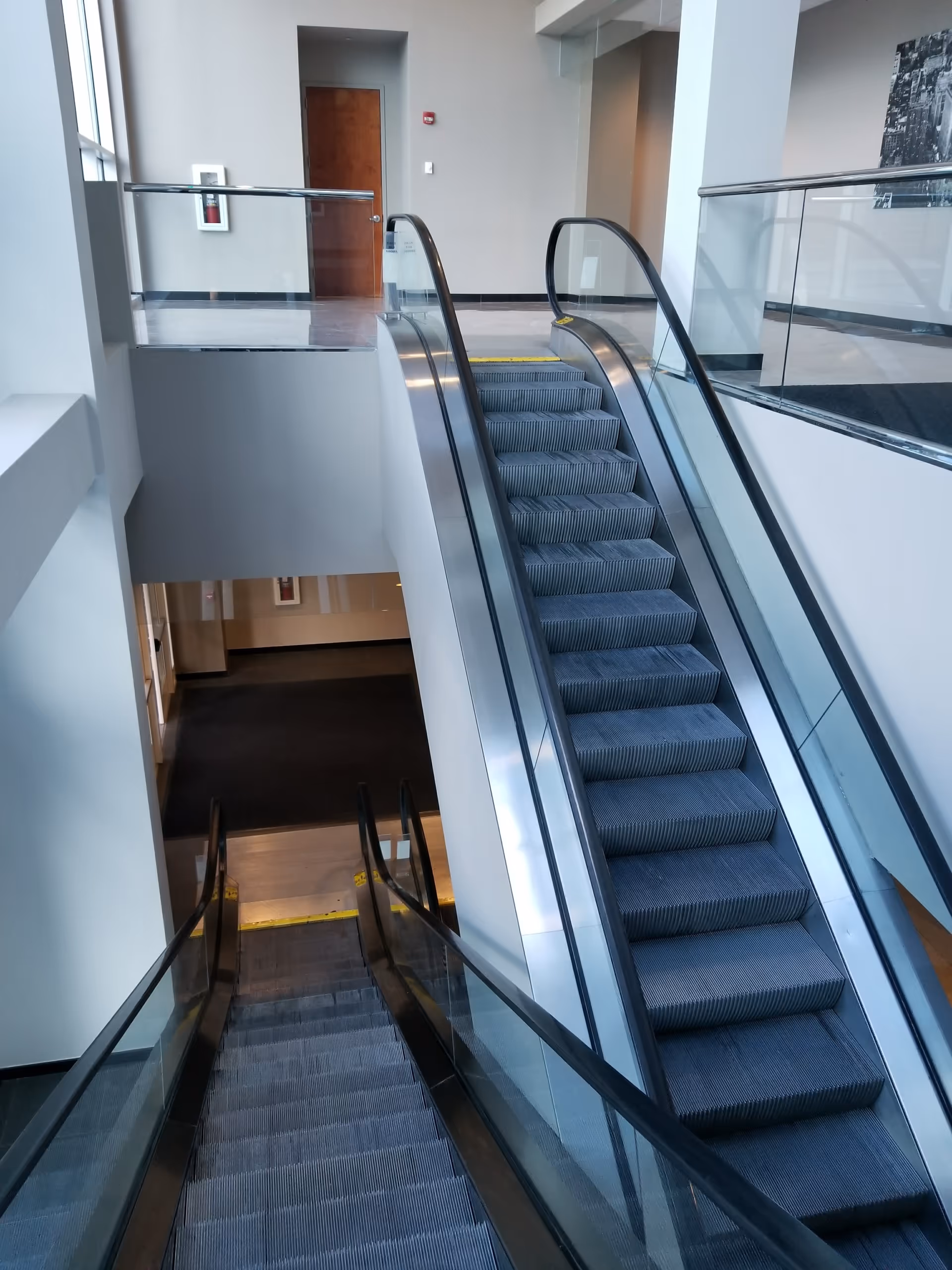 Interior view of an escalator and stairs in a modern medical facility.