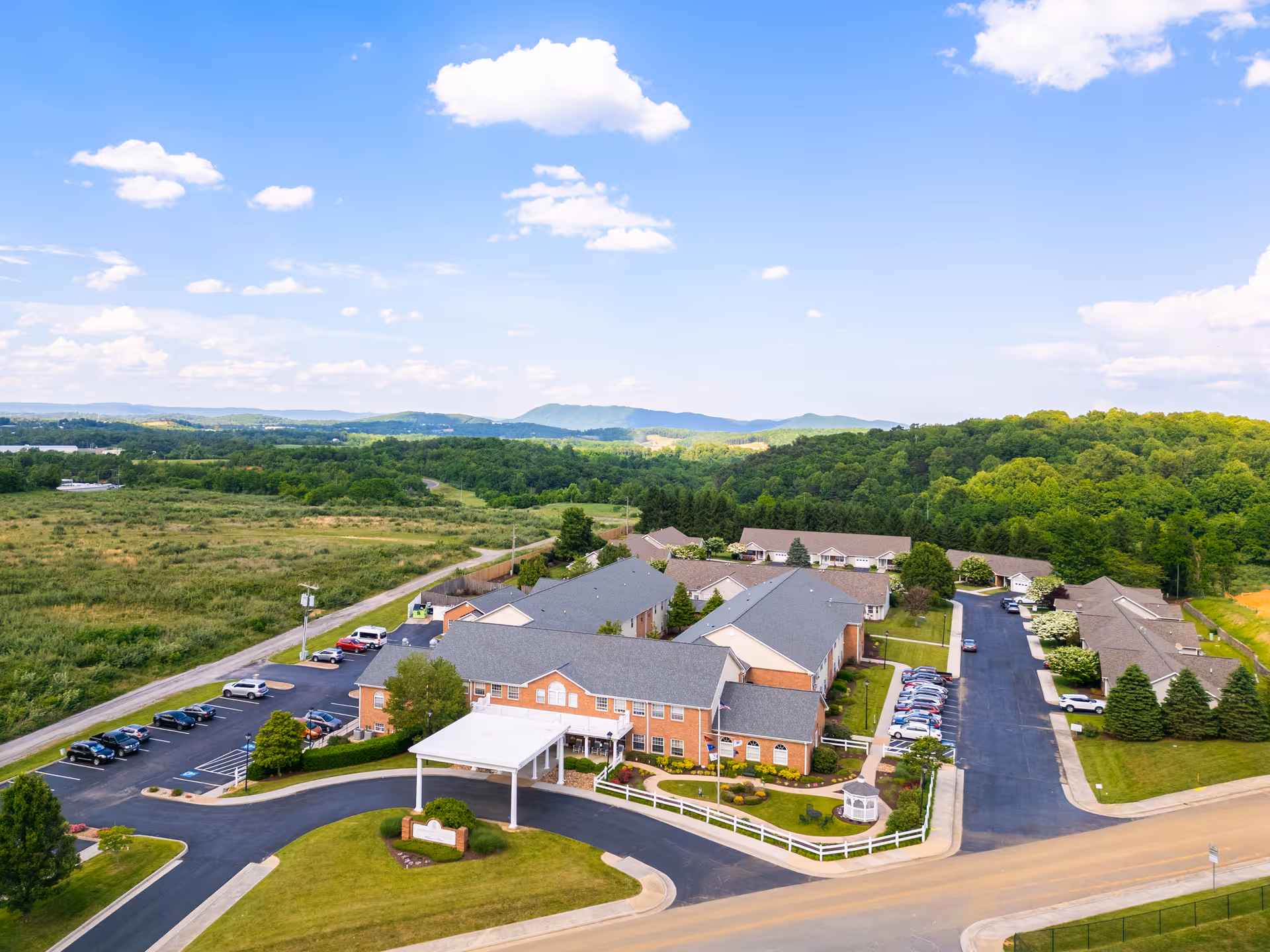 Aerial view of Commonwealth Senior Living at Christiansburg campus with brick buildings, parking, and green landscape.