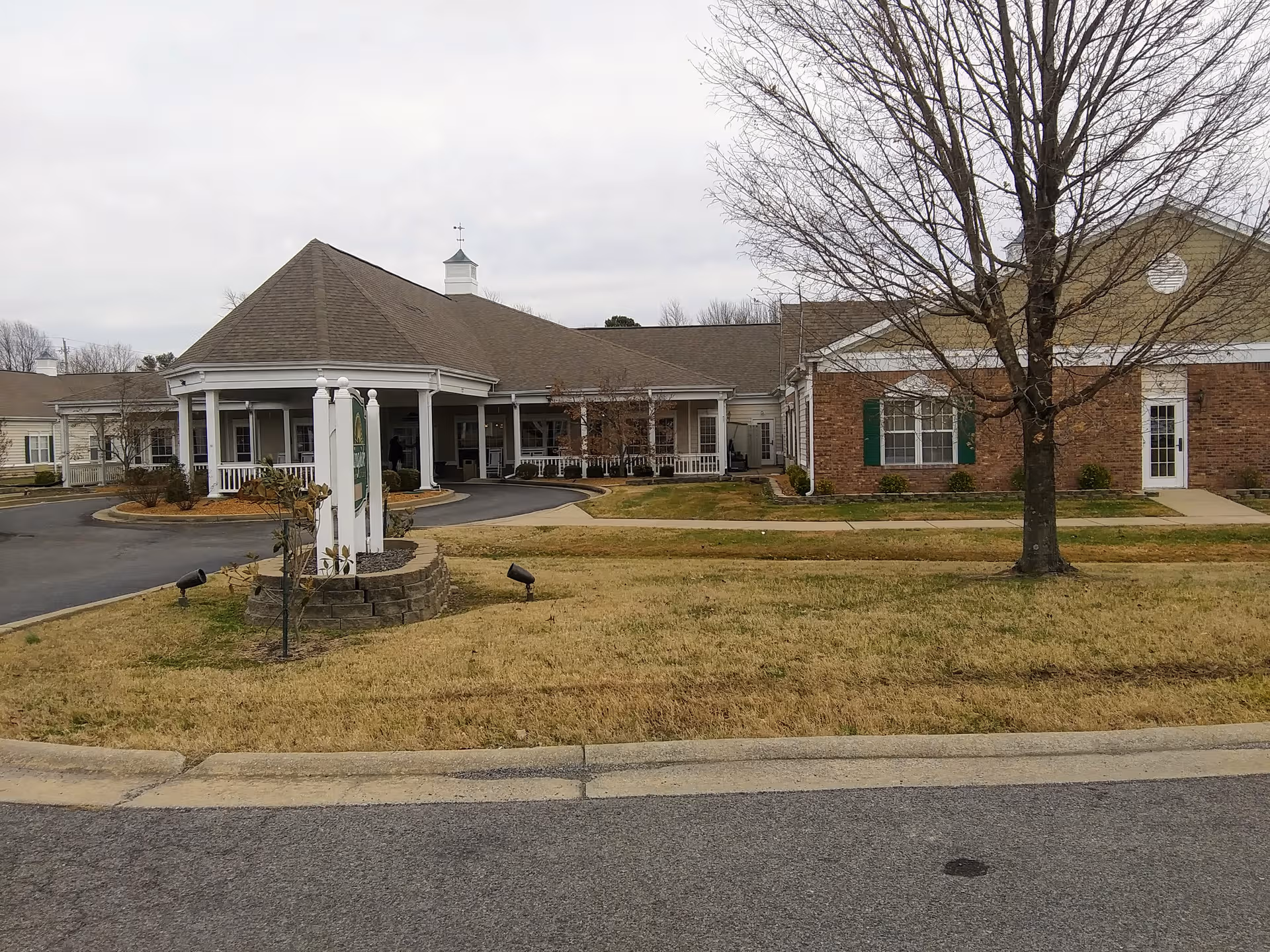 Exterior view of The Neighborhood at Paducah, featuring a brick building, lawn, and front entrance.