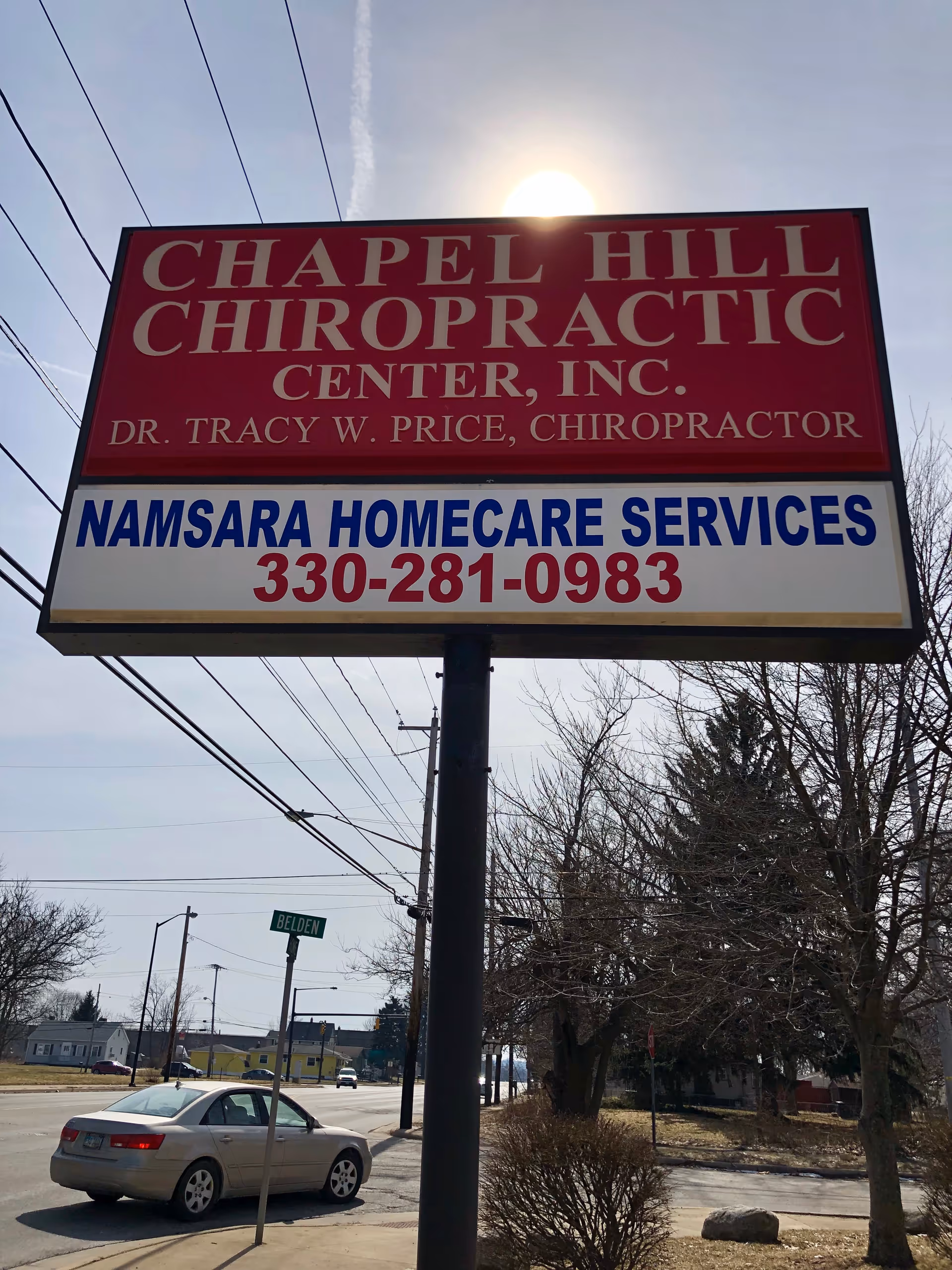 Outdoor roadside sign advertising Namsara Homecare Services beside bare trees