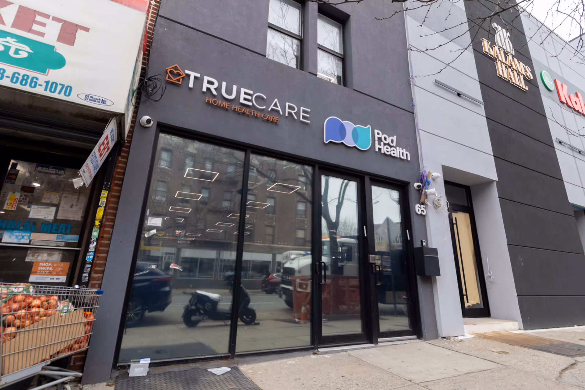 Exterior storefront showing Pod Health and TrueCare signs on a modern building.