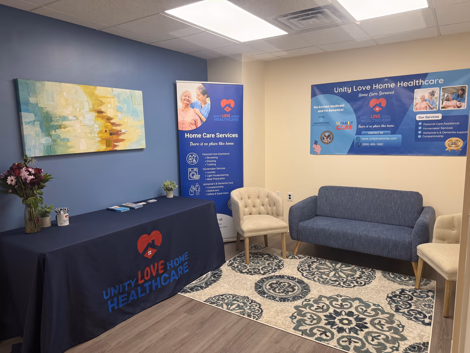 Indoor reception area with Unity Love Home Healthcare branding, posters, and seating.