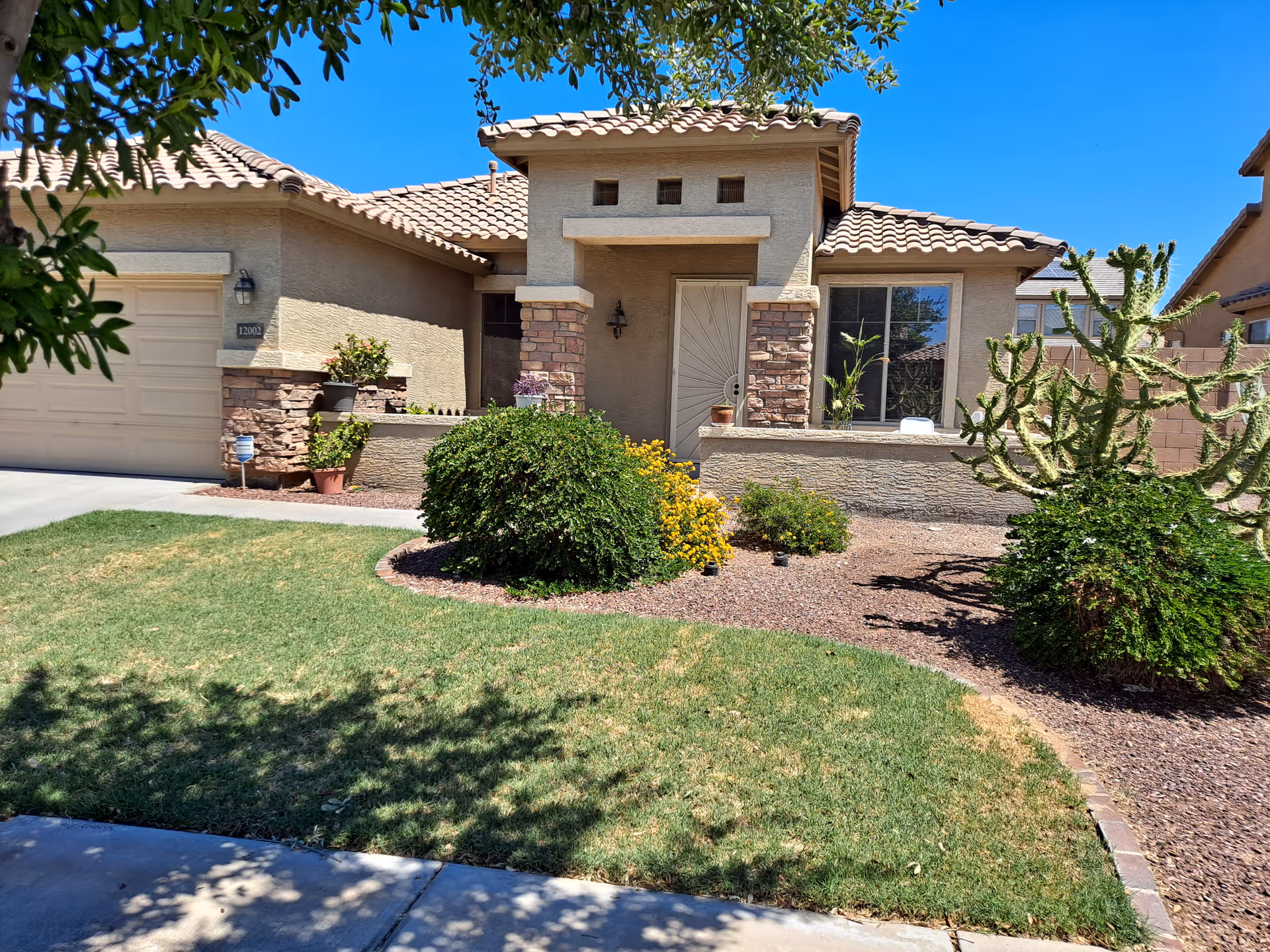 Front exterior of Rhoda's Assisted Living Home with a landscaped yard and driveway.