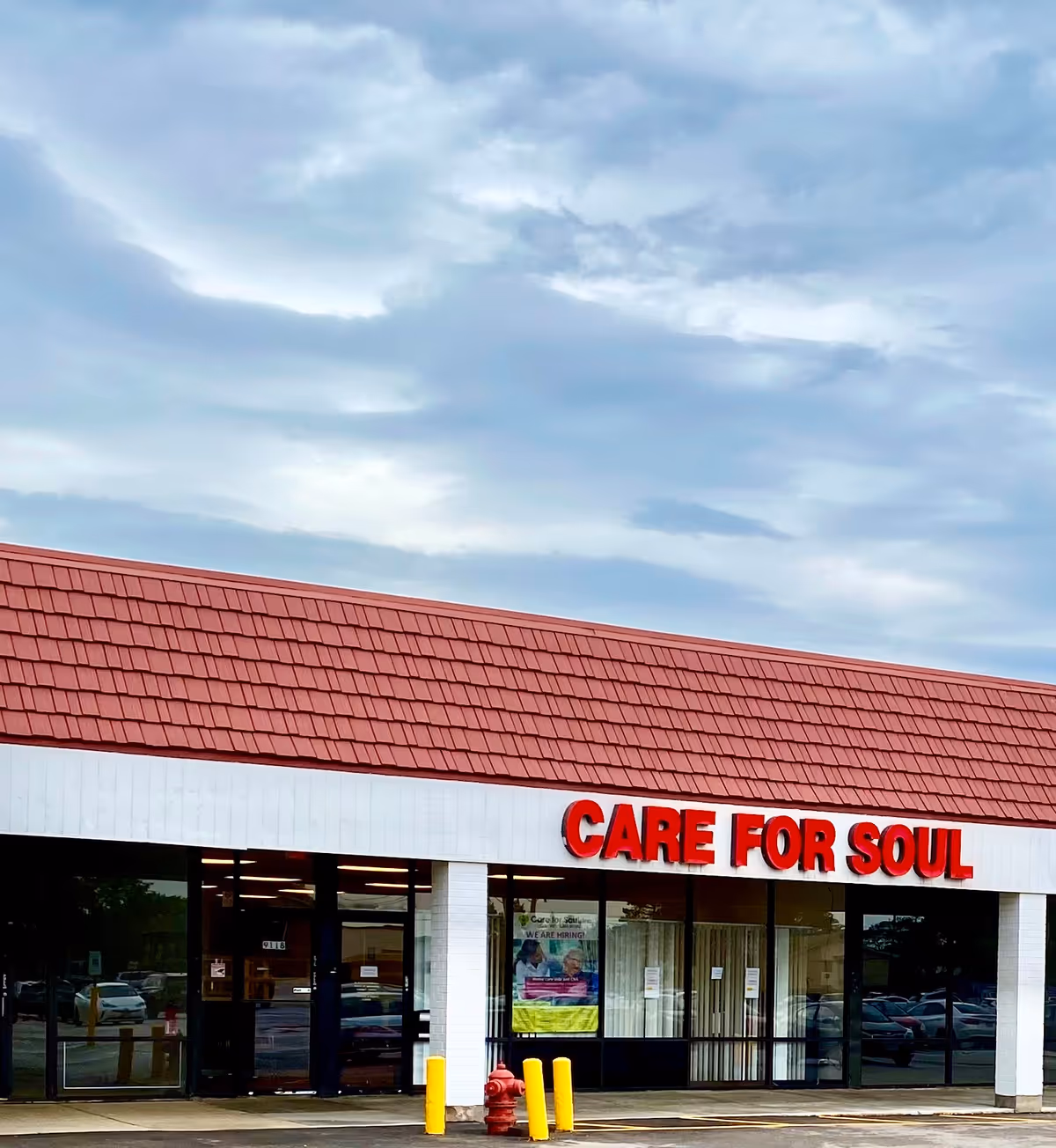 Exterior view of a building with a red roof and CARE FOR SOUL sign.