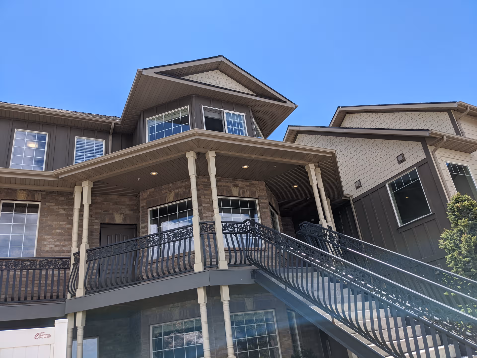 Exterior view of Rocky Mountain Care Grove Creek Assisted Living entrance with a staircase and canopy.