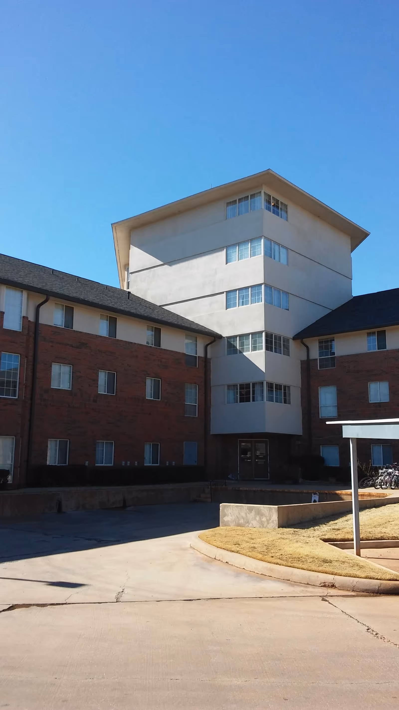 Exterior view of Tealridge Independent Living building, brick wings with a white central tower.