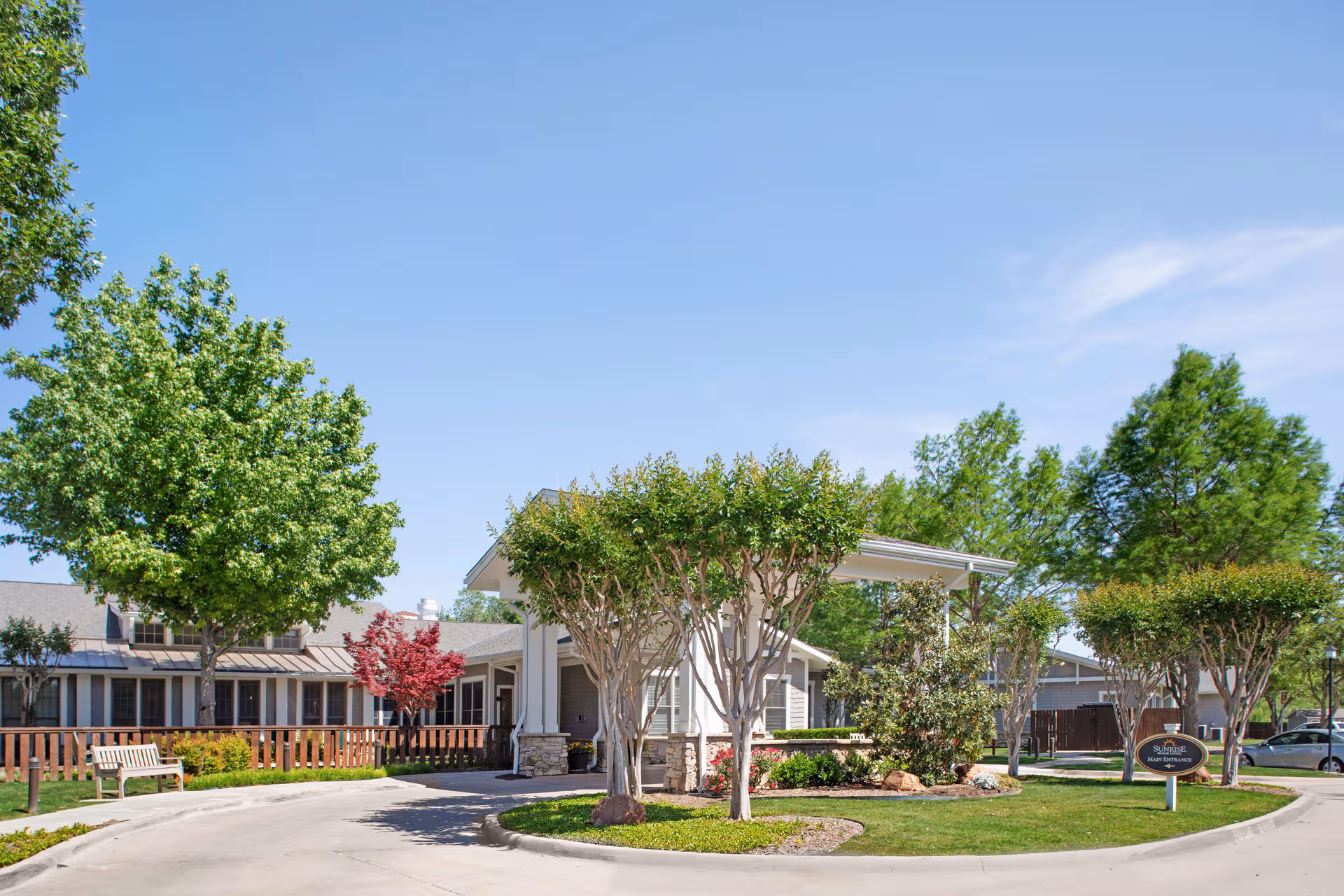 Exterior view of Sunrise of Fort Worth with a circular driveway and landscaped entrance.